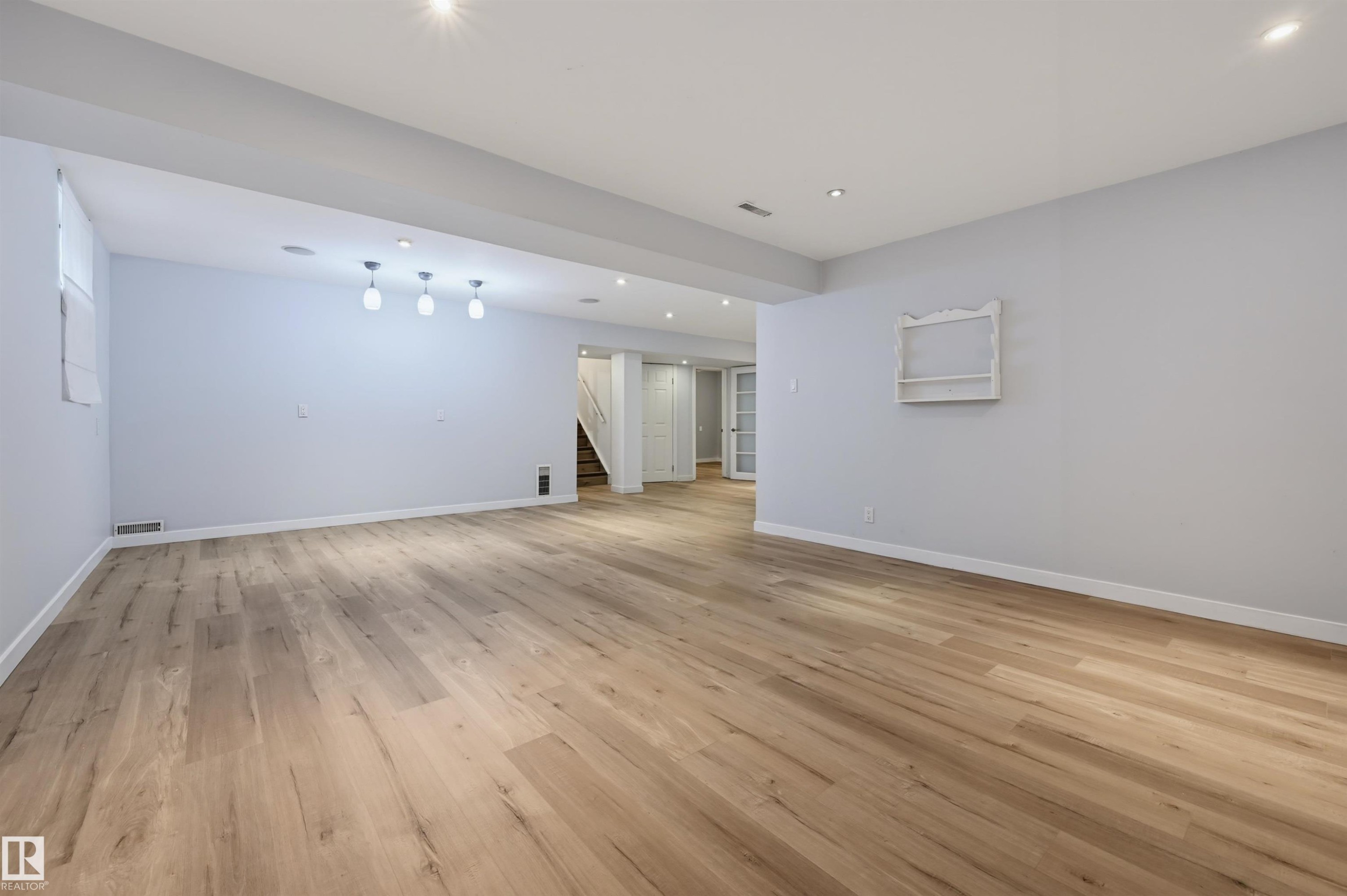 Spacious room featuring wood-finish flooring, recessed lighting, and a window - 9127 149 Street Nw, Edmonton, AB - Indoor Photo Showing Other Room