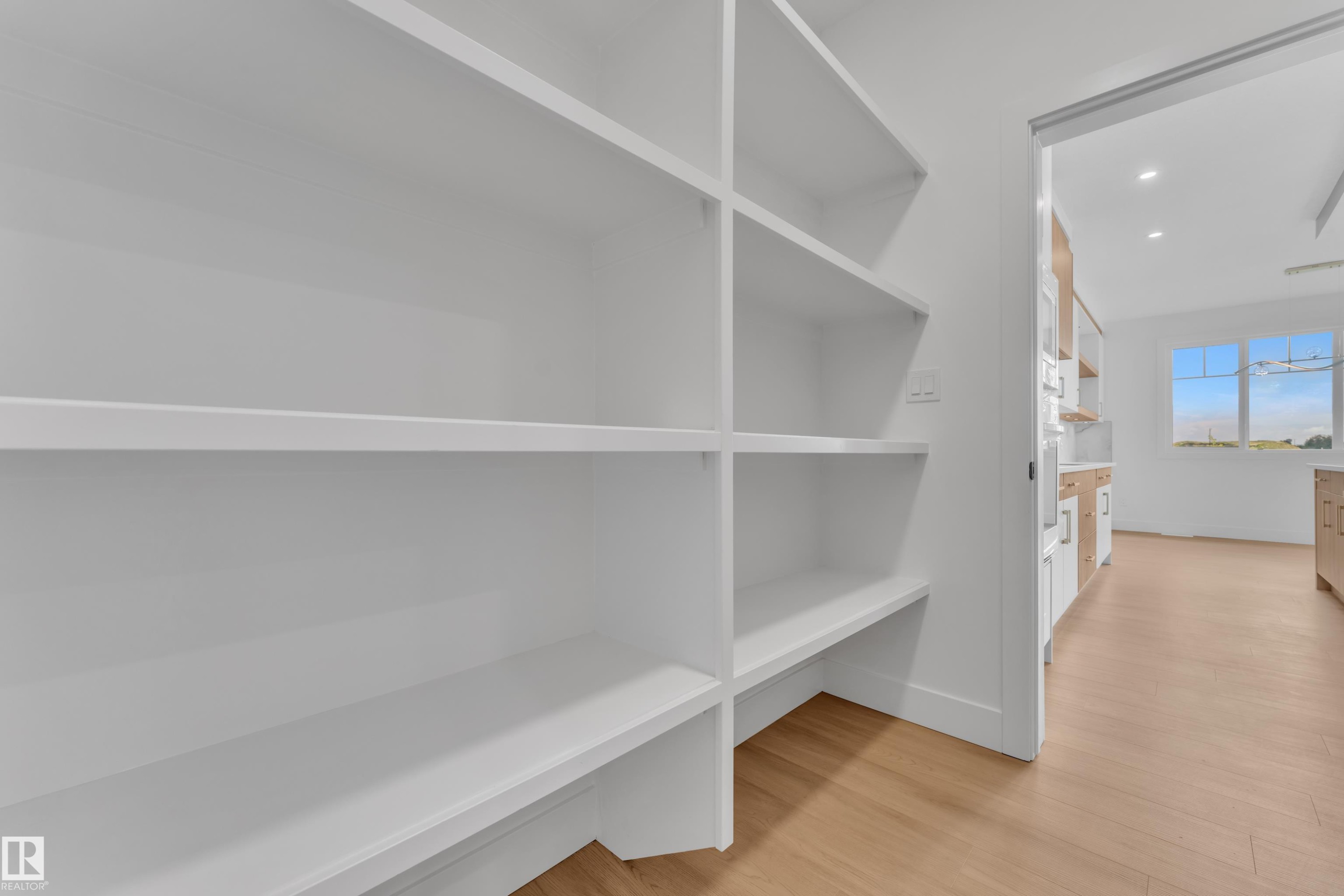 Built-in shelving with light wood-finish flooring - 764 Astoria Way, Devon, AB - Indoor With Storage