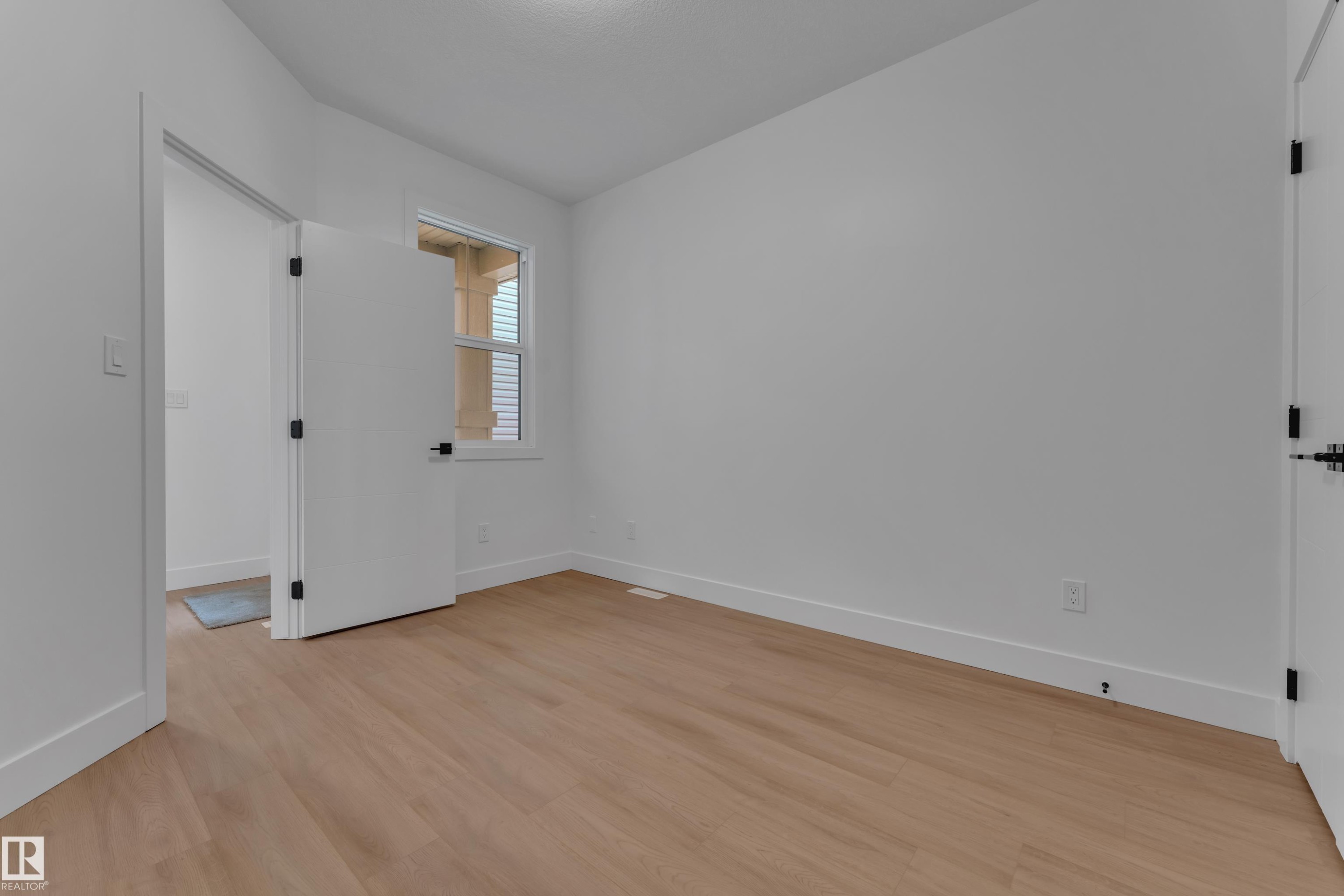 Wood-finish flooring with crisp white walls and trim - 764 Astoria Way, Devon, AB - Indoor Photo Showing Other Room