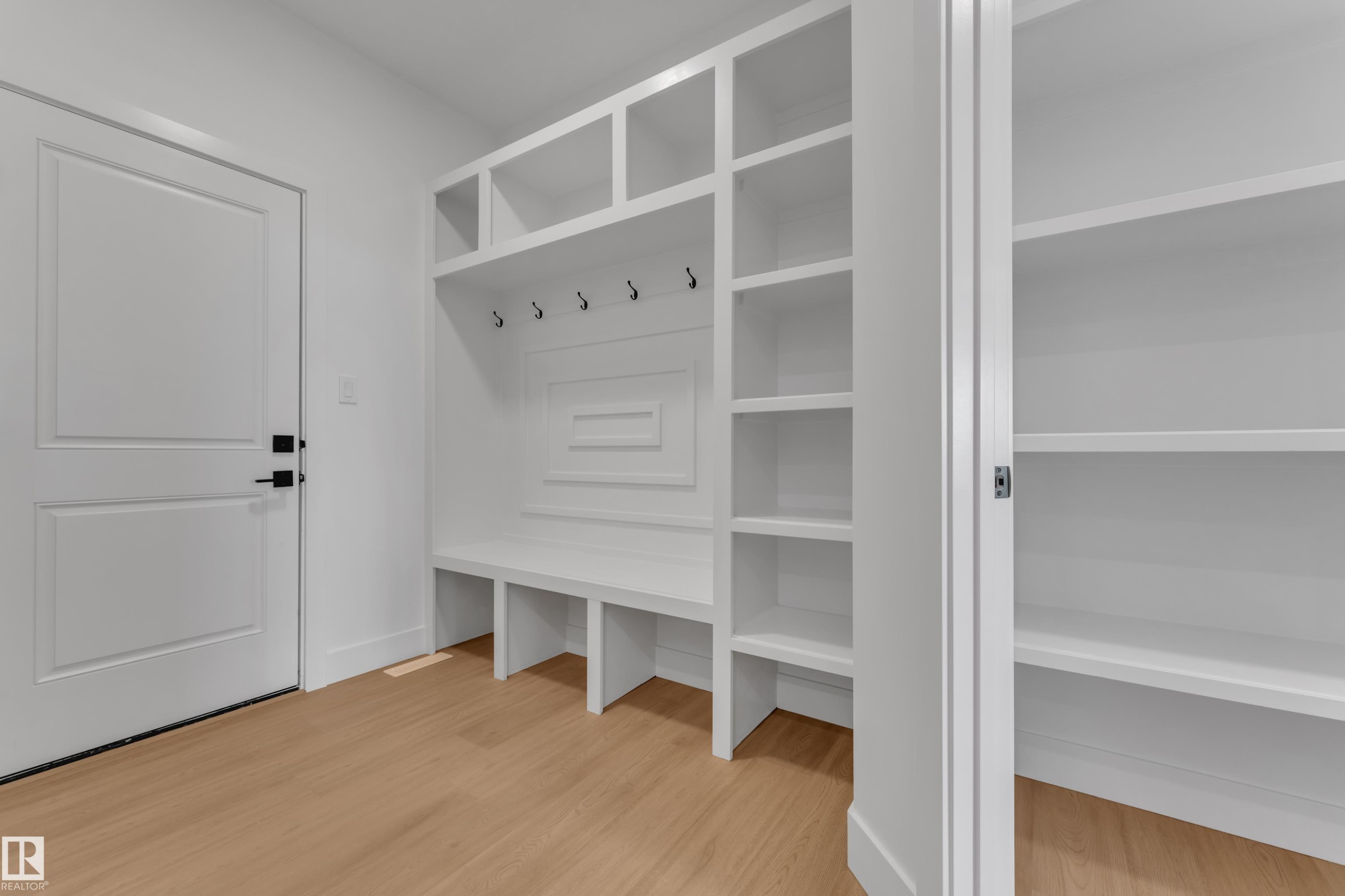 Wood-finish flooring with white built-in shelving, a built-in bench, and coat hooks - 764 Astoria Way, Devon, AB - Indoor