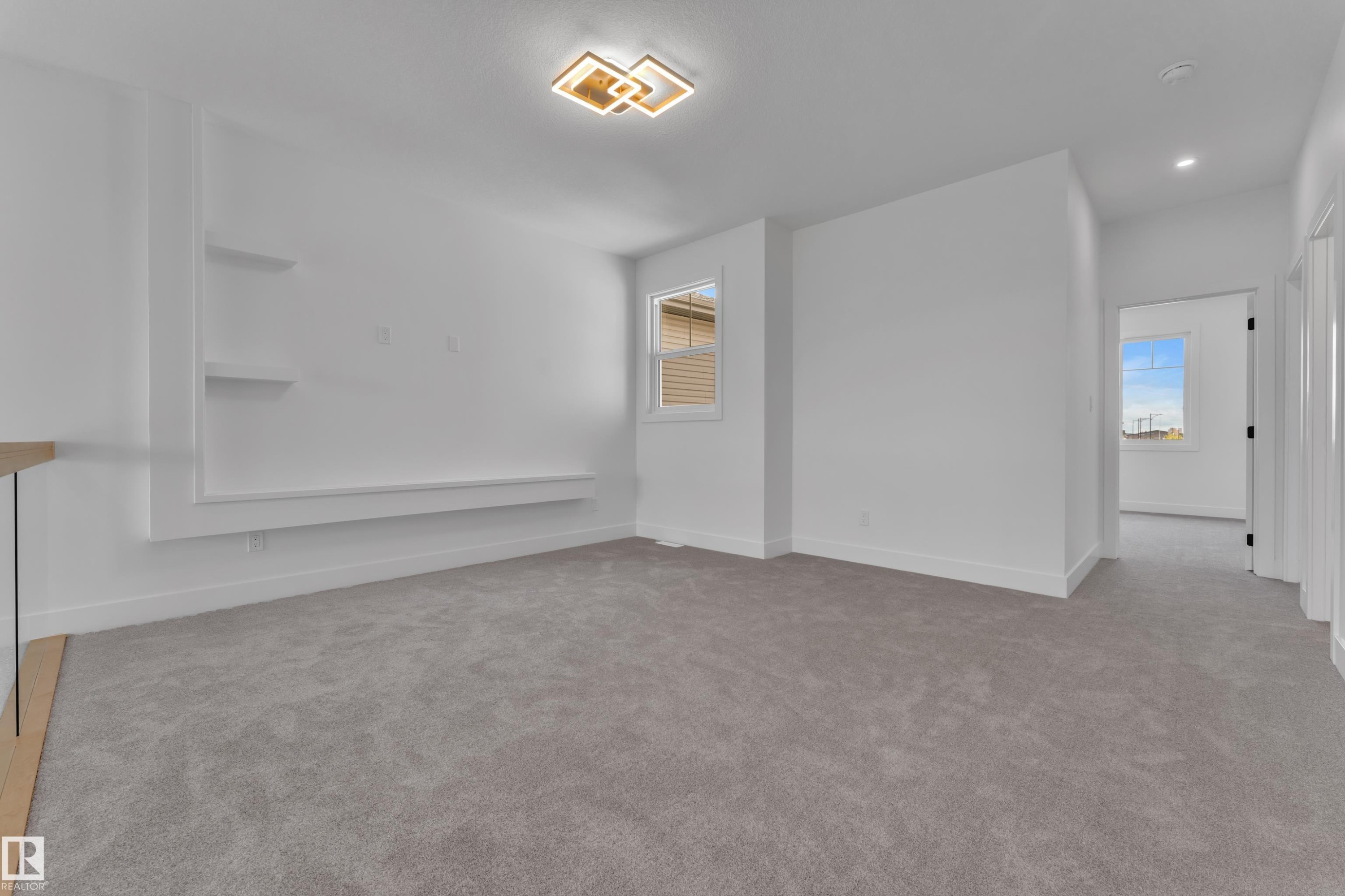Plush grey carpeting, built-in shelving, white walls, modern ceiling light fixture, and a window with horizontal blinds - 764 Astoria Way, Devon, AB - Indoor Photo Showing Other Room