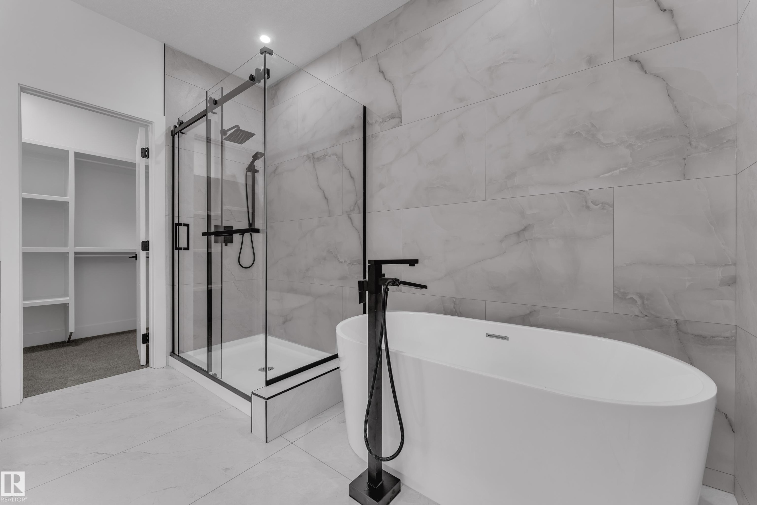 Freestanding soaking tub, walk-in shower with matte black fixtures, full-height wall tiling, and tile flooring - 764 Astoria Way, Devon, AB - Indoor Photo Showing Bathroom