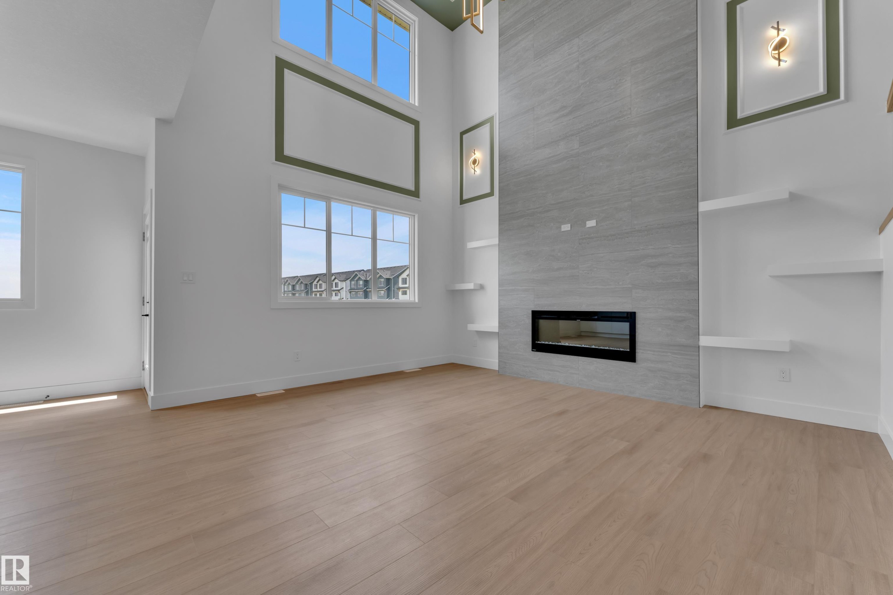 Expansive living space featuring wood-finish flooring, a tall ceiling, and abundant natural light from large windows - 764 Astoria Way, Devon, AB - Indoor With Fireplace