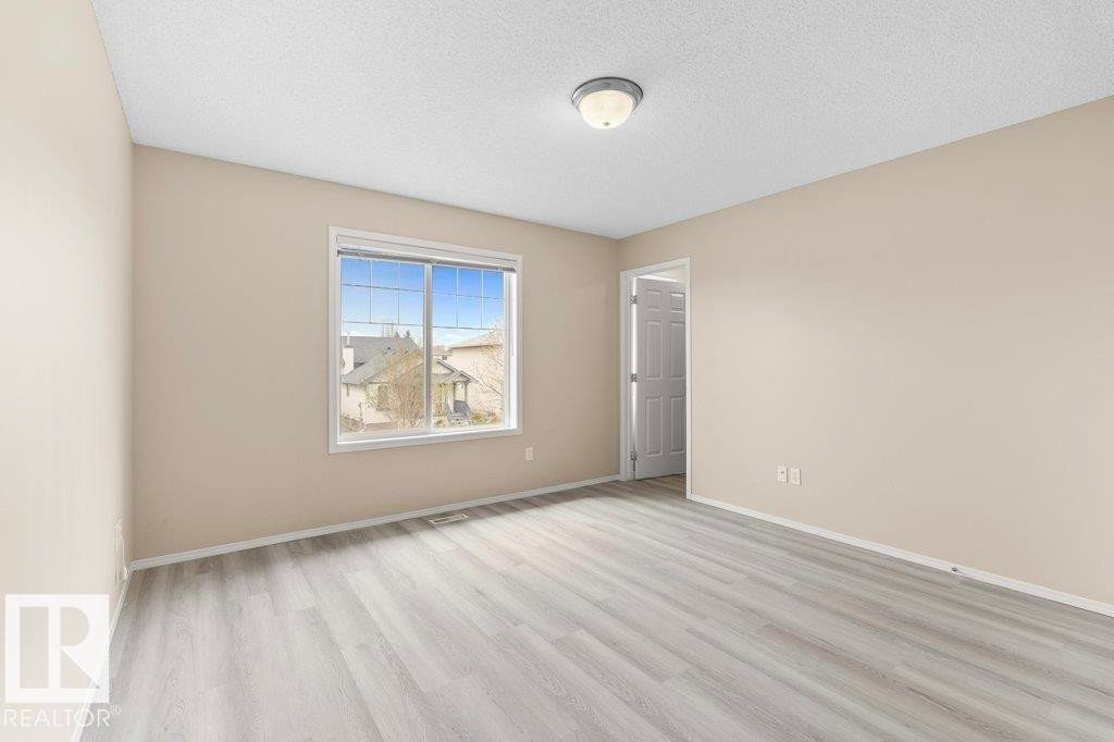 Neutral-toned walls complement light wood-finish flooring - 21344 88 Avenue Nw, Edmonton, AB - Indoor Photo Showing Other Room