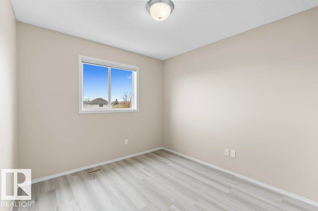 Neutral painted walls with light wood-finish flooring - 21344 88 Avenue Nw, Edmonton, AB - Indoor Photo Showing Other Room
