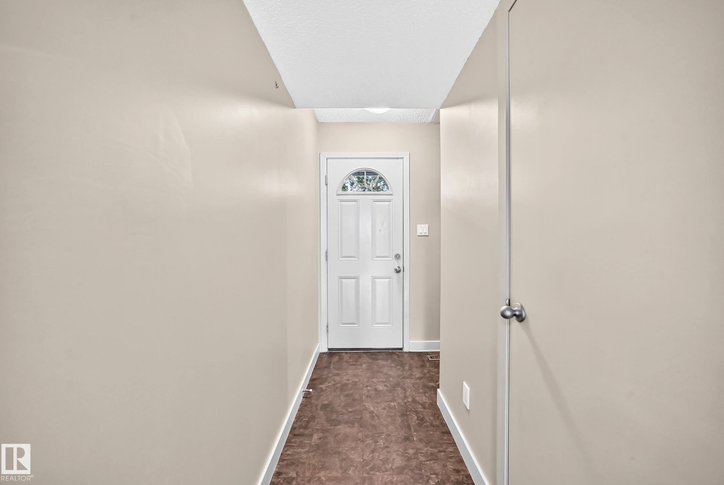 Entryway featuring a white paneled door with an arched glass insert, light-toned walls, and dark-toned flooring - 6416 180 Street Nw, Edmonton, AB - Indoor Photo Showing Other Room