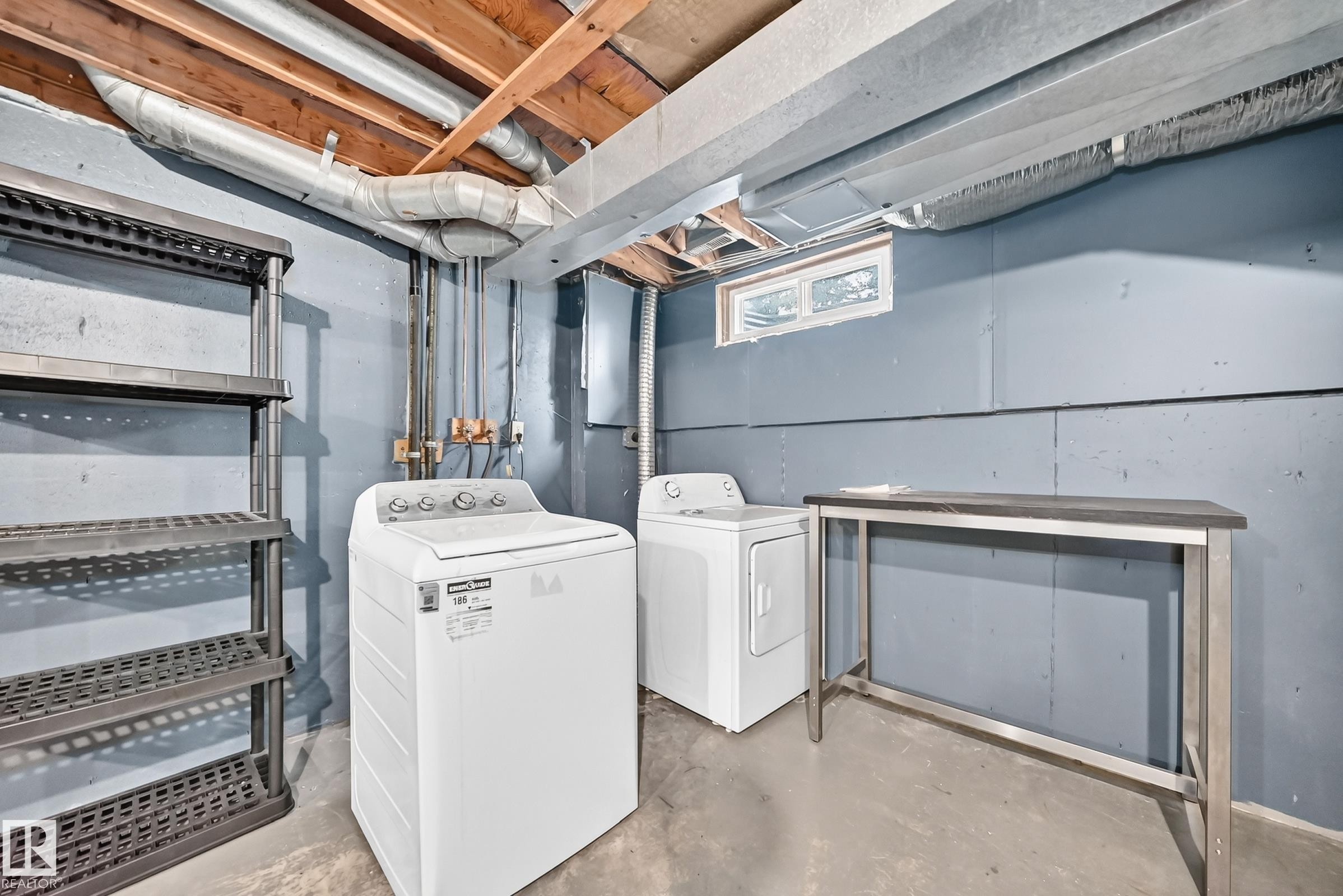 Concrete flooring, exposed ceiling joists, and a window - 6416 180 Street Nw, Edmonton, AB - Indoor Photo Showing Laundry Room