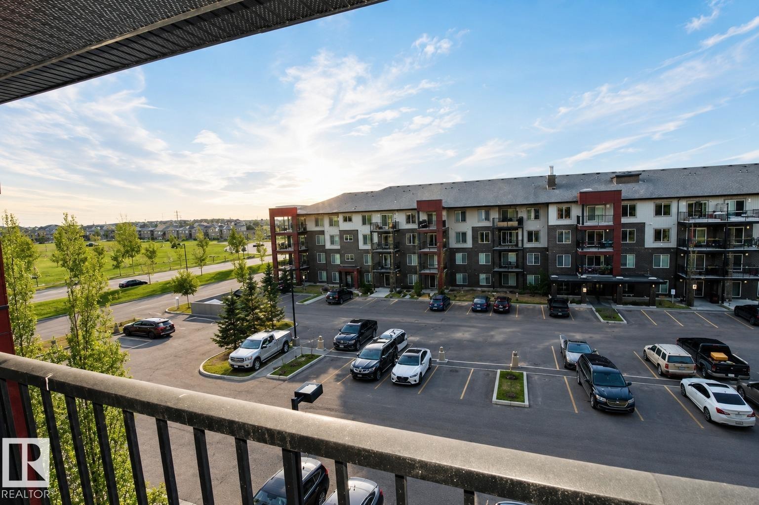 Multi-story building featuring balconies, dedicated parking, and a paved lot - #430 5515 7 Av Sw, Edmonton, AB - Outdoor With Balcony