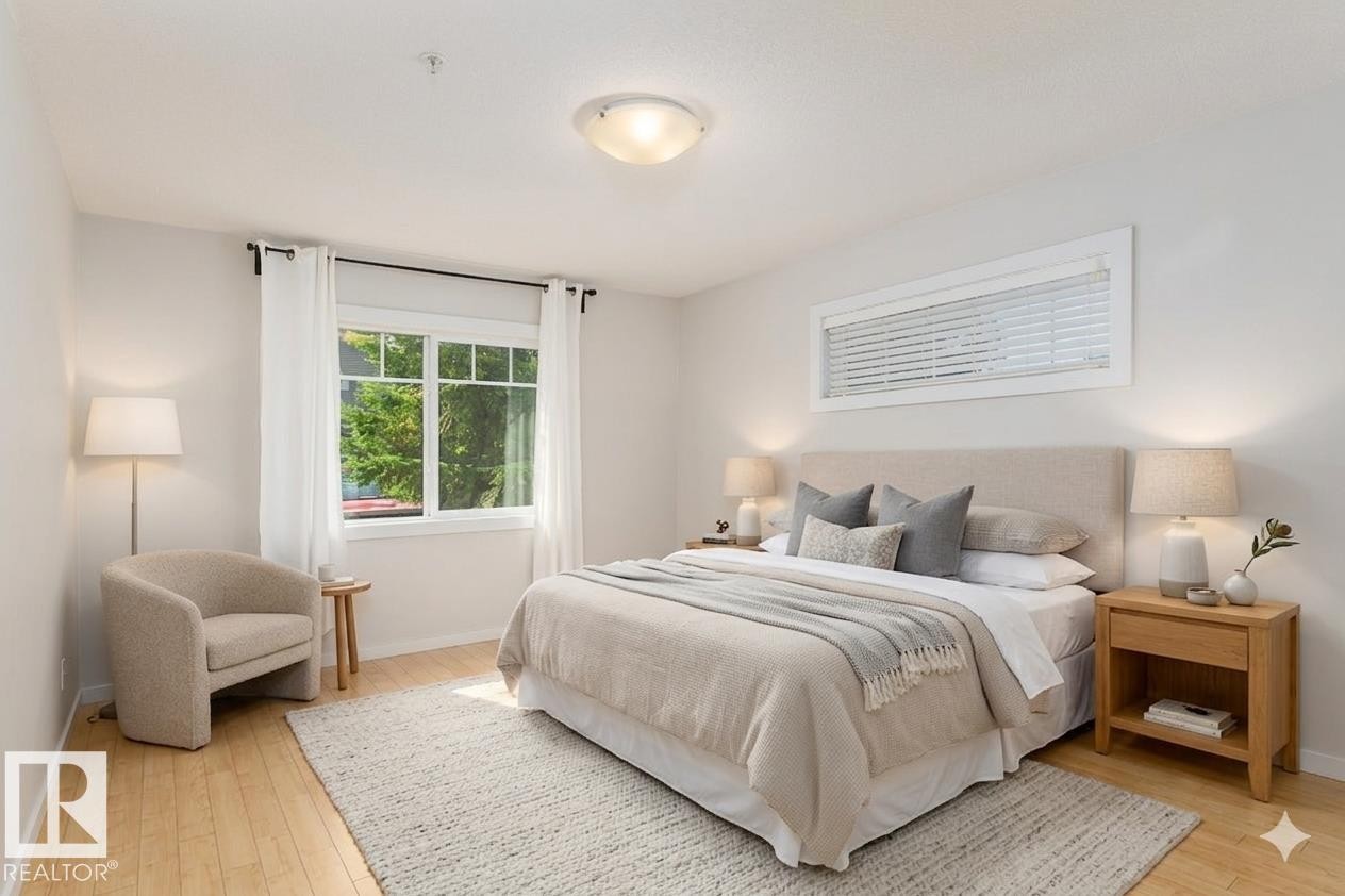 Recessed lighting, wood-finish flooring, and a large window with white trim - #110 9523 160 Av Nw, Edmonton, AB