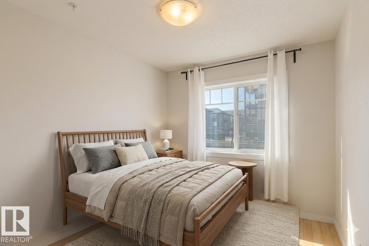 Recessed lighting with a flush-mount fixture, light wood-finish flooring, and a large window - #110 9523 160 Av Nw, Edmonton, AB