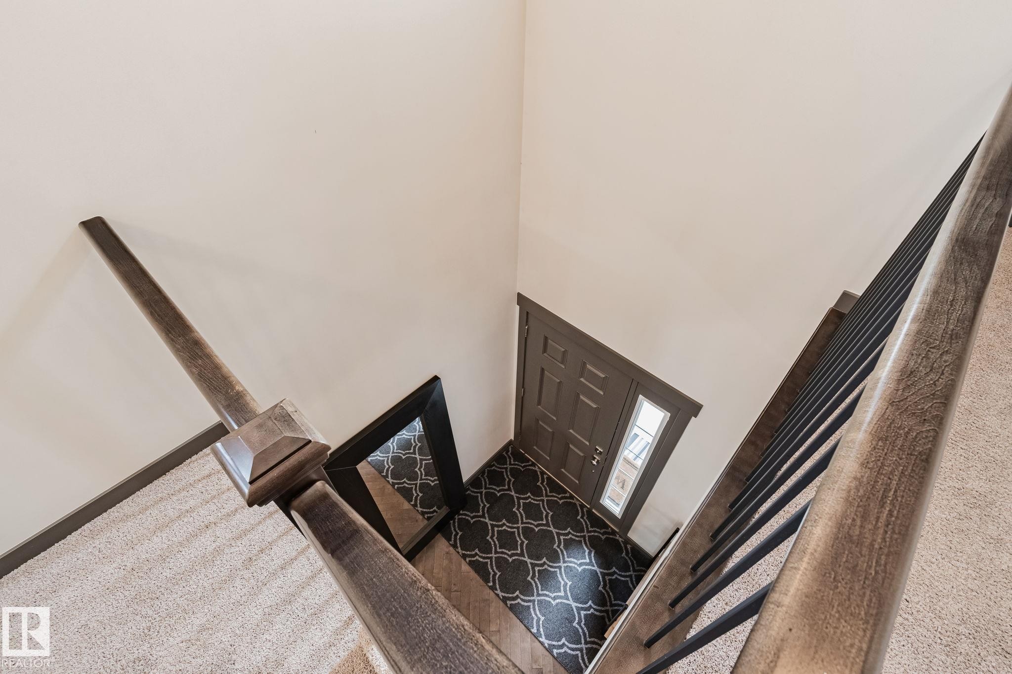 Warm wood-finish handrail with metal balusters - 1337 Secord Landing Nw, Edmonton, AB - Indoor Photo Showing Other Room