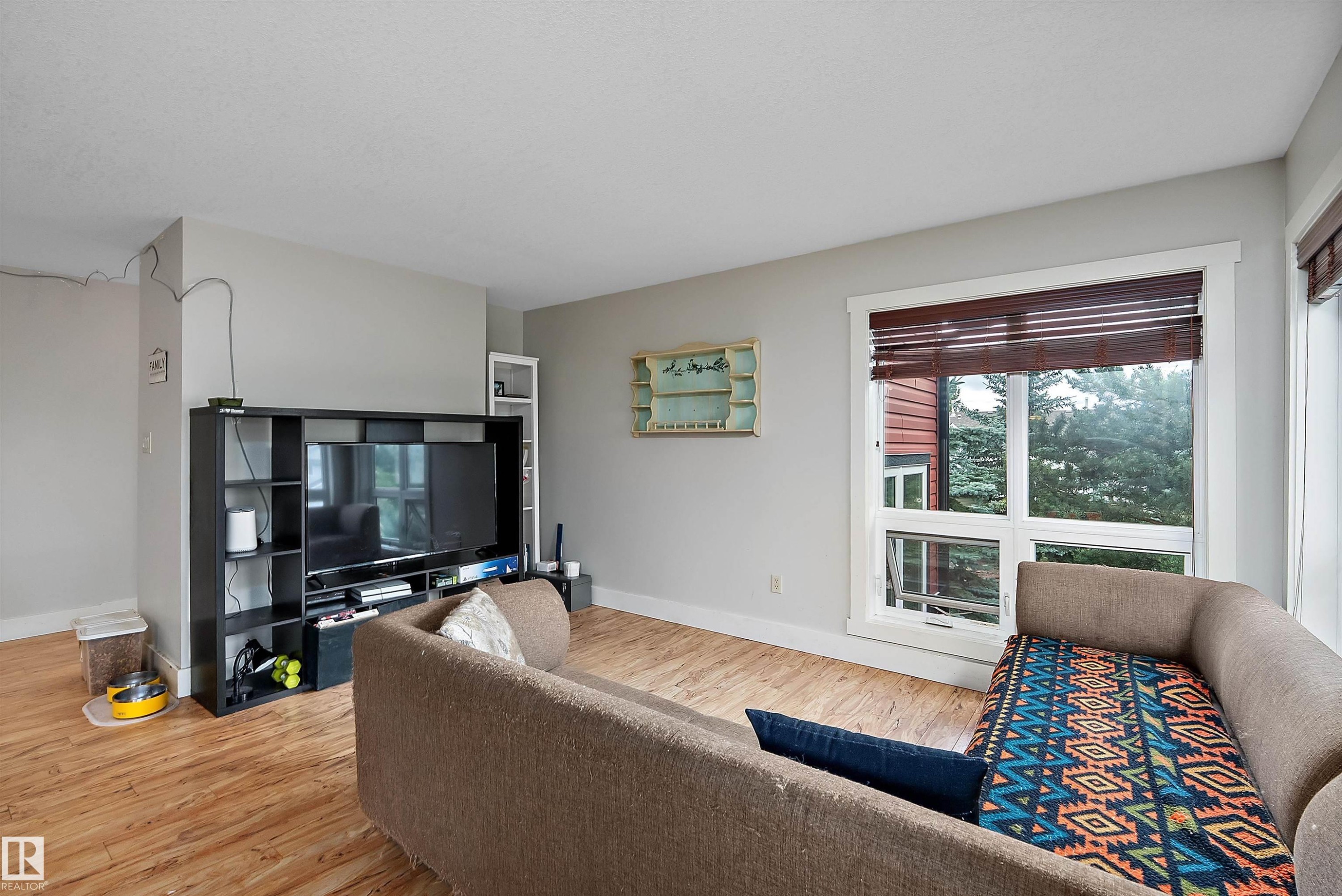 Wood-finish flooring, light grey wall paint, and white trim throughout - 203 Graybriar Green, Stony Plain, AB - Indoor Photo Showing Living Room