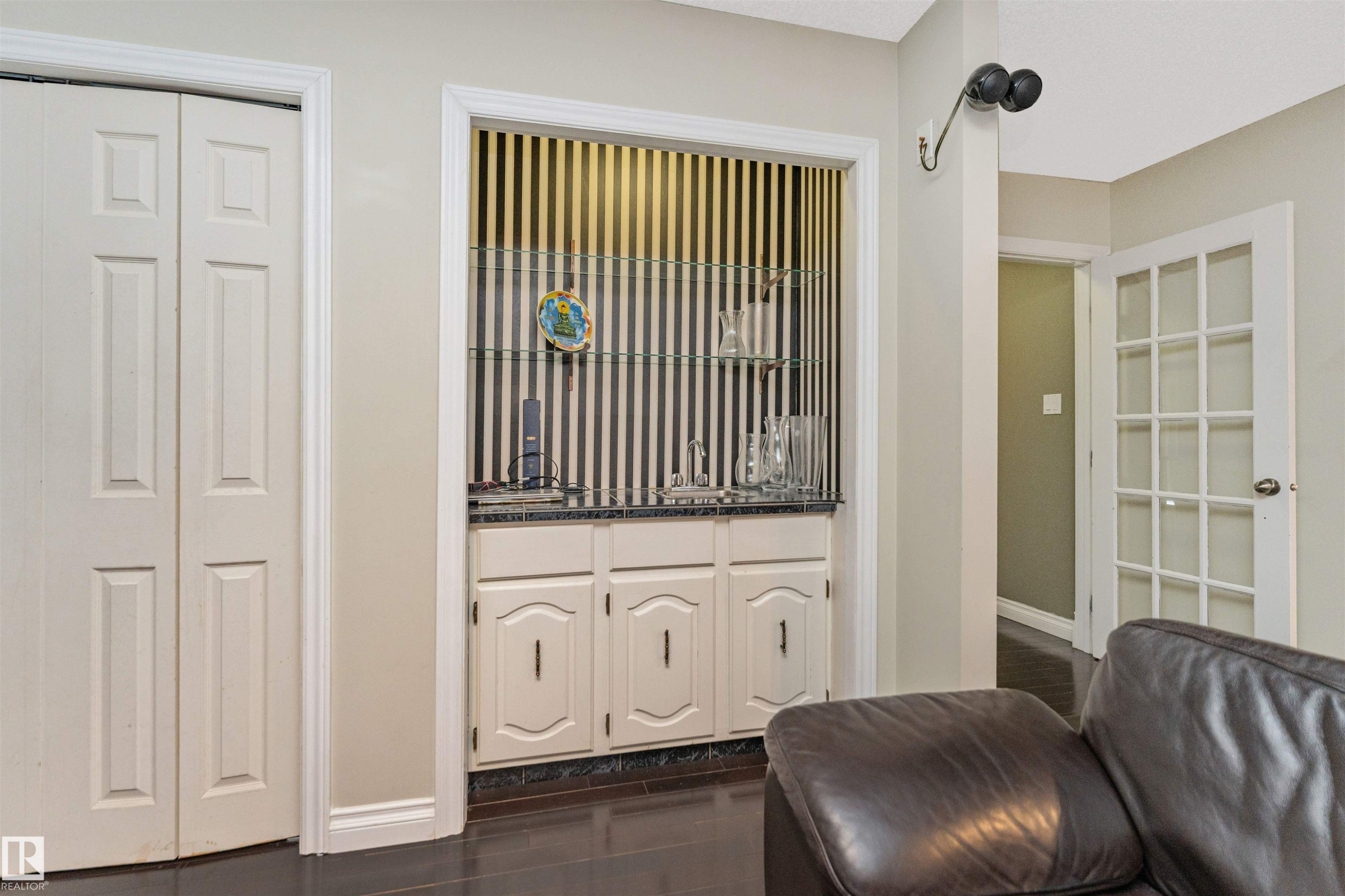 Built-in wet bar featuring a sink, base cabinetry, and glass shelving - 6016 177 Street Nw, Edmonton, AB - Indoor Photo Showing Other Room