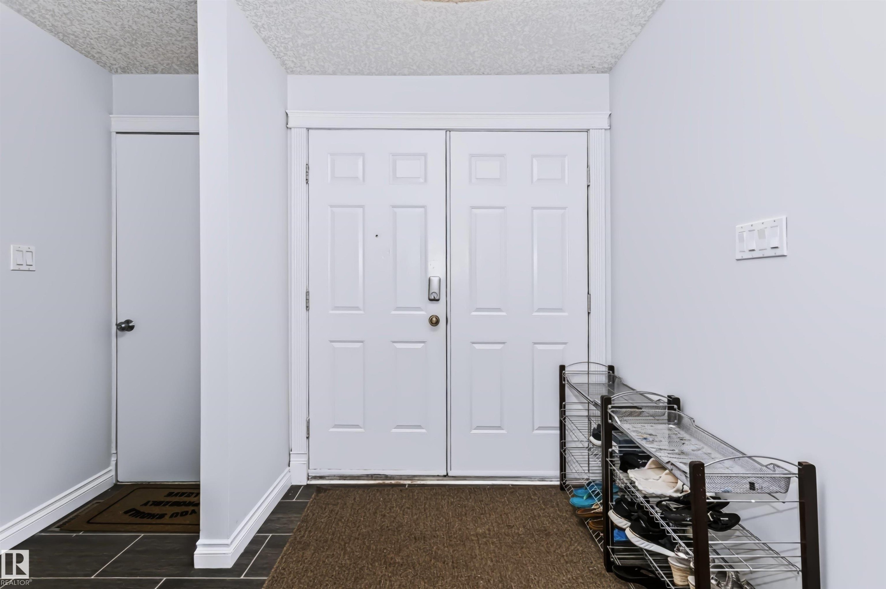 Dual panel entry door with panel detailing - 6016 177 Street Nw, Edmonton, AB - Indoor Photo Showing Other Room