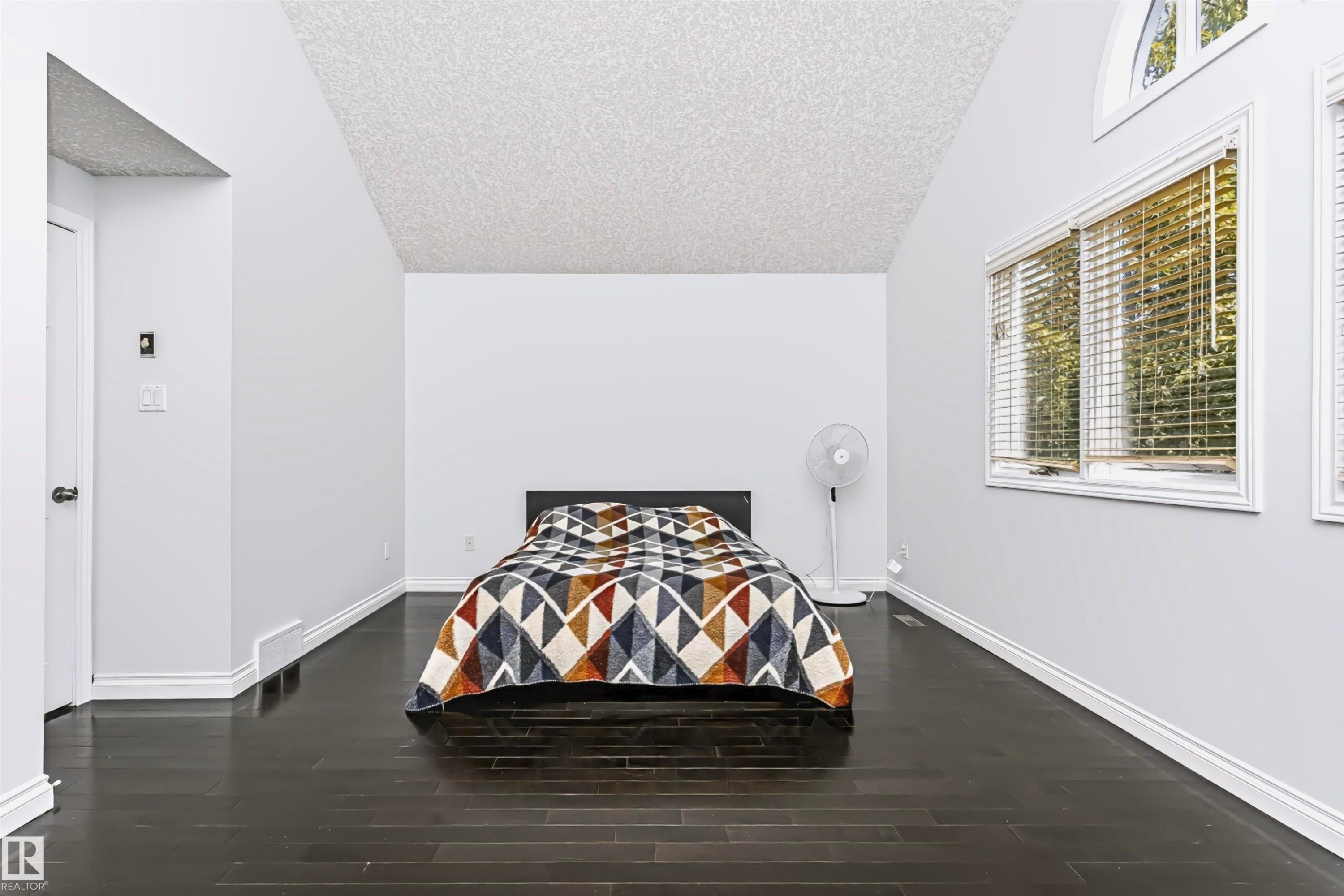 Vaulted ceiling with dark wood-finish flooring, white trim, and arched window - 6016 177 Street Nw, Edmonton, AB - Indoor