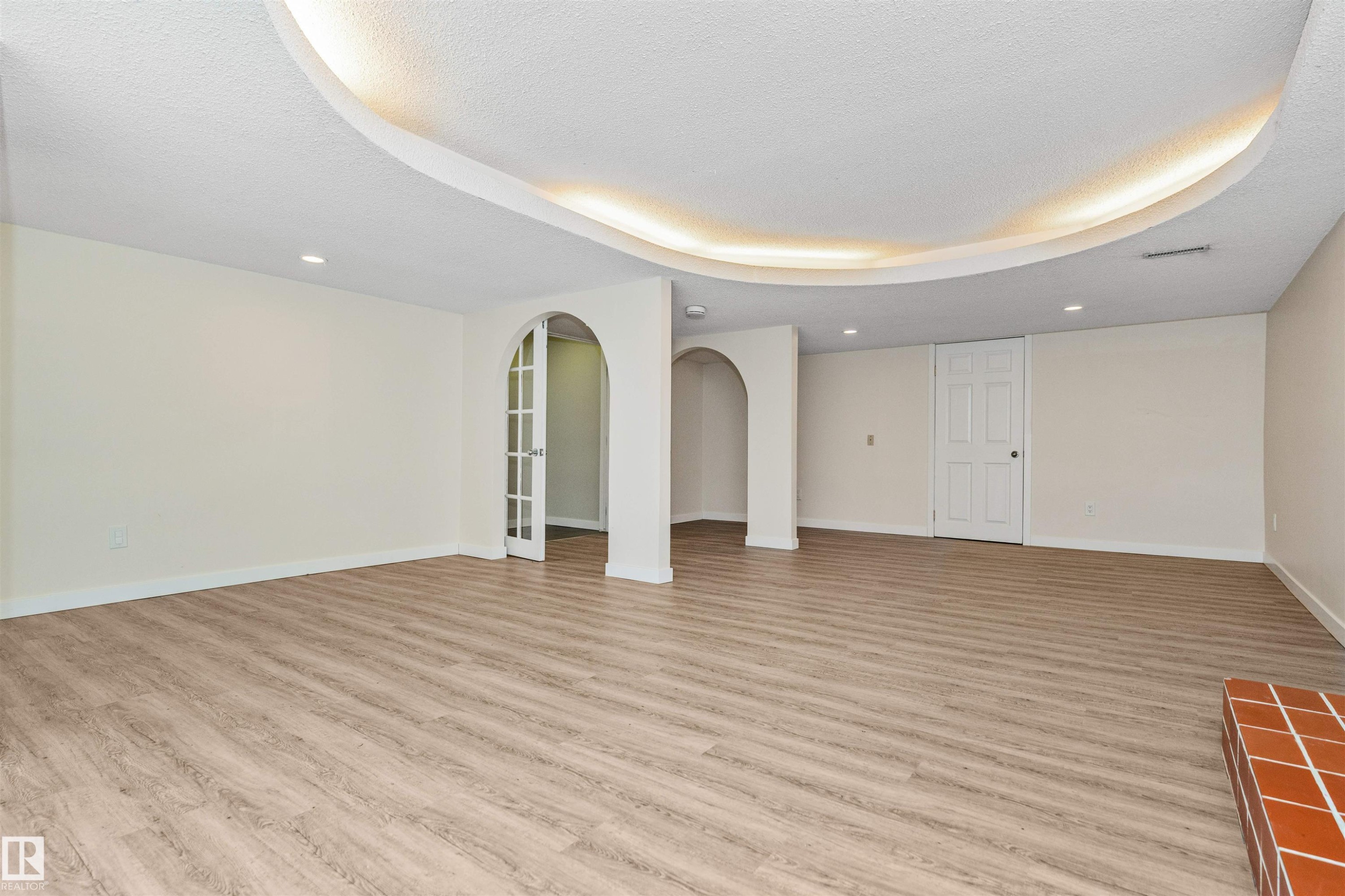 Spacious room featuring wood-finish flooring, recessed lighting, and a cove ceiling with accent lighting - 6016 177 Street Nw, Edmonton, AB - Indoor Photo Showing Other Room