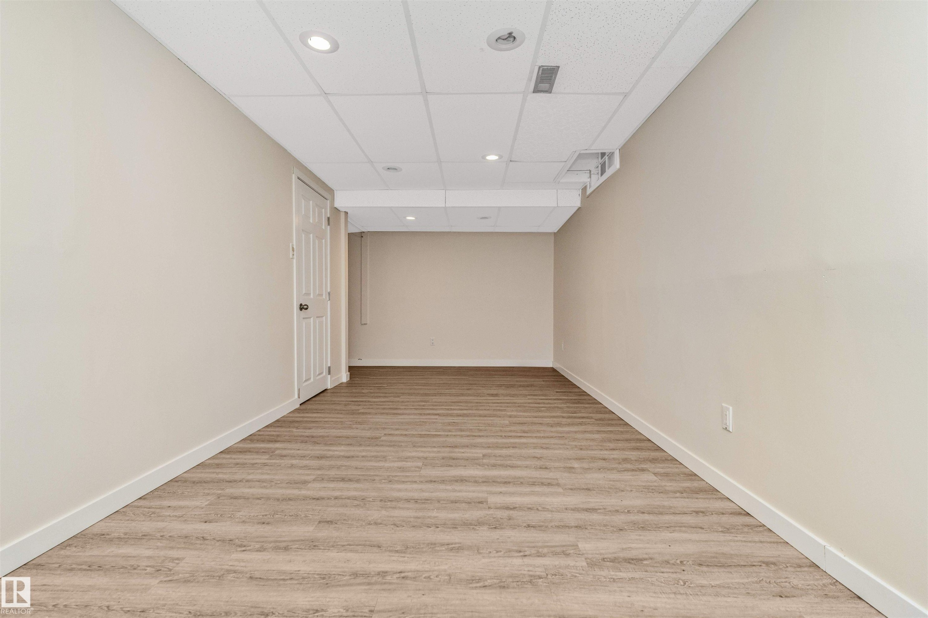 Neutral wall tones, wood-finish flooring, recessed lighting, and a drop ceiling - 6016 177 Street Nw, Edmonton, AB - Indoor Photo Showing Other Room