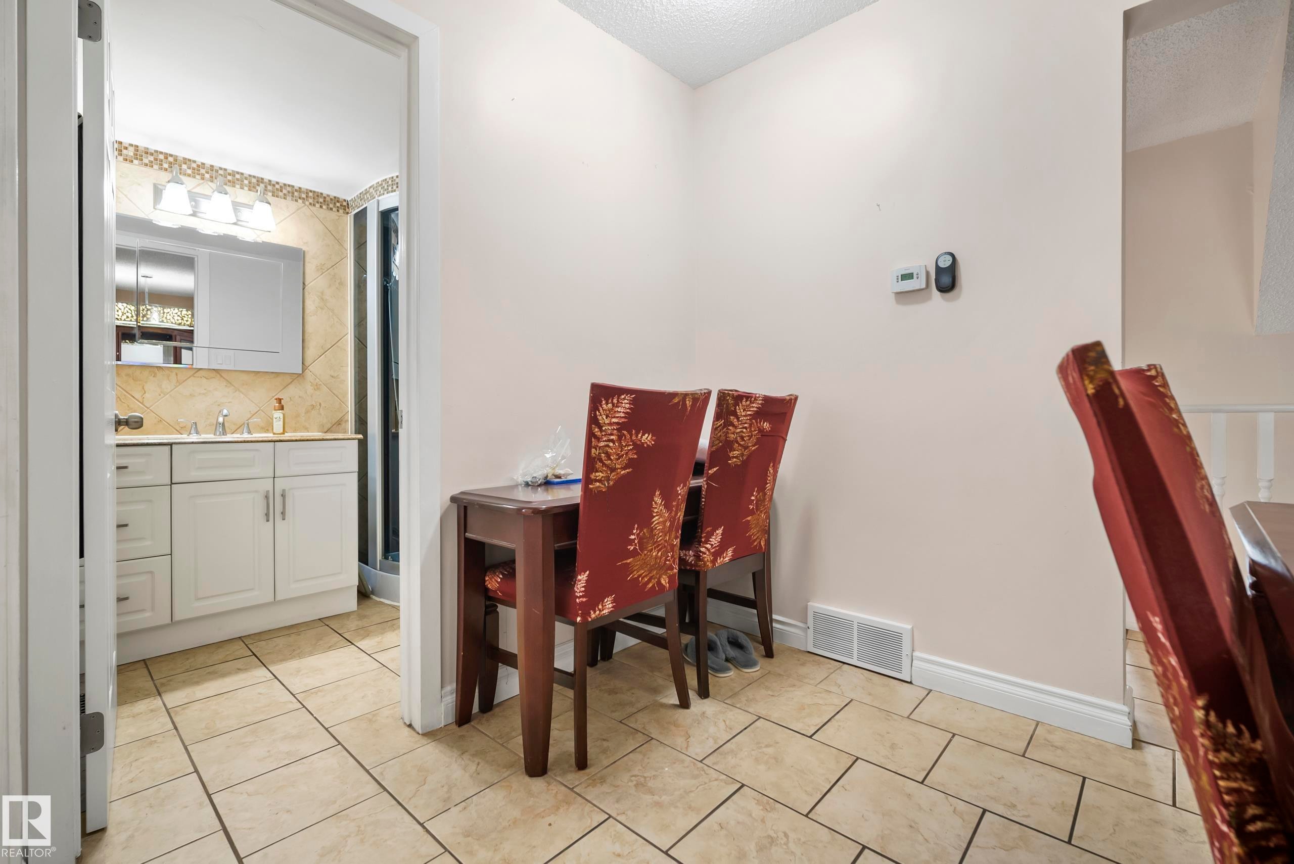 Main Floor Bathroom featuring a single vanity with storage, tiled backsplash, and recessed lighting. Also, area for a desk. - #25 3811 85 St Nw, Edmonton, AB - Indoor