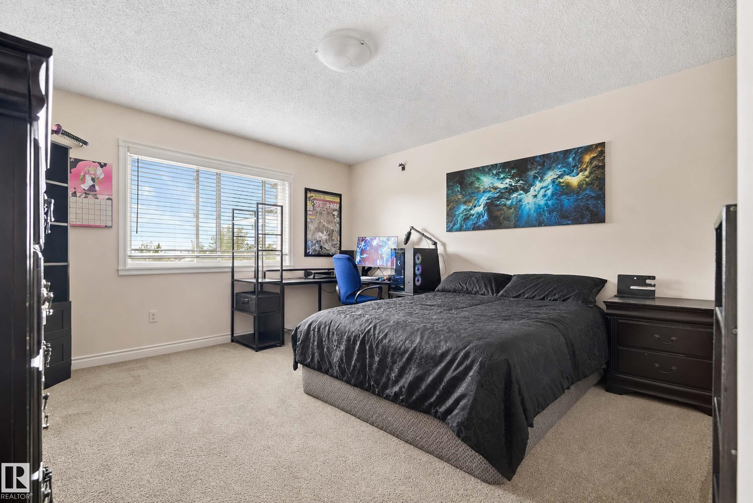 Wall-to-wall carpeting with a large window and white trim - #25 3811 85 St Nw, Edmonton, AB - Indoor Photo Showing Bedroom