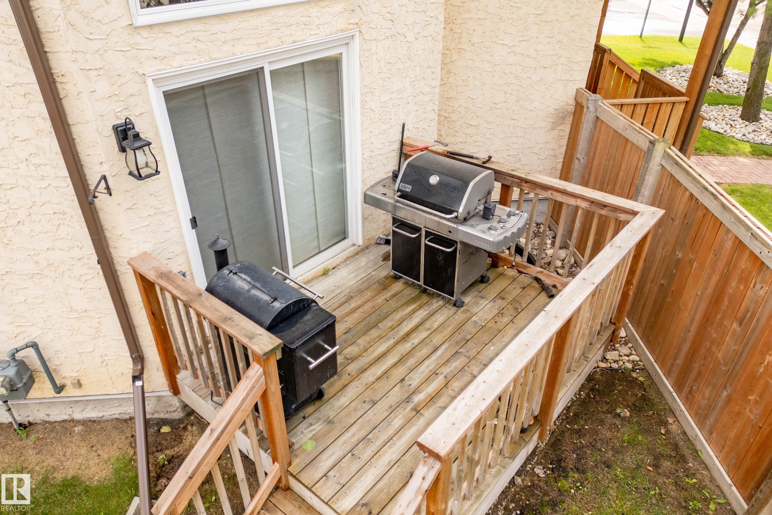 Outdoor wooden deck with railing, sliding glass door access, and perimeter fencing - #25 3811 85 St Nw, Edmonton, AB - Outdoor With Deck Patio Veranda