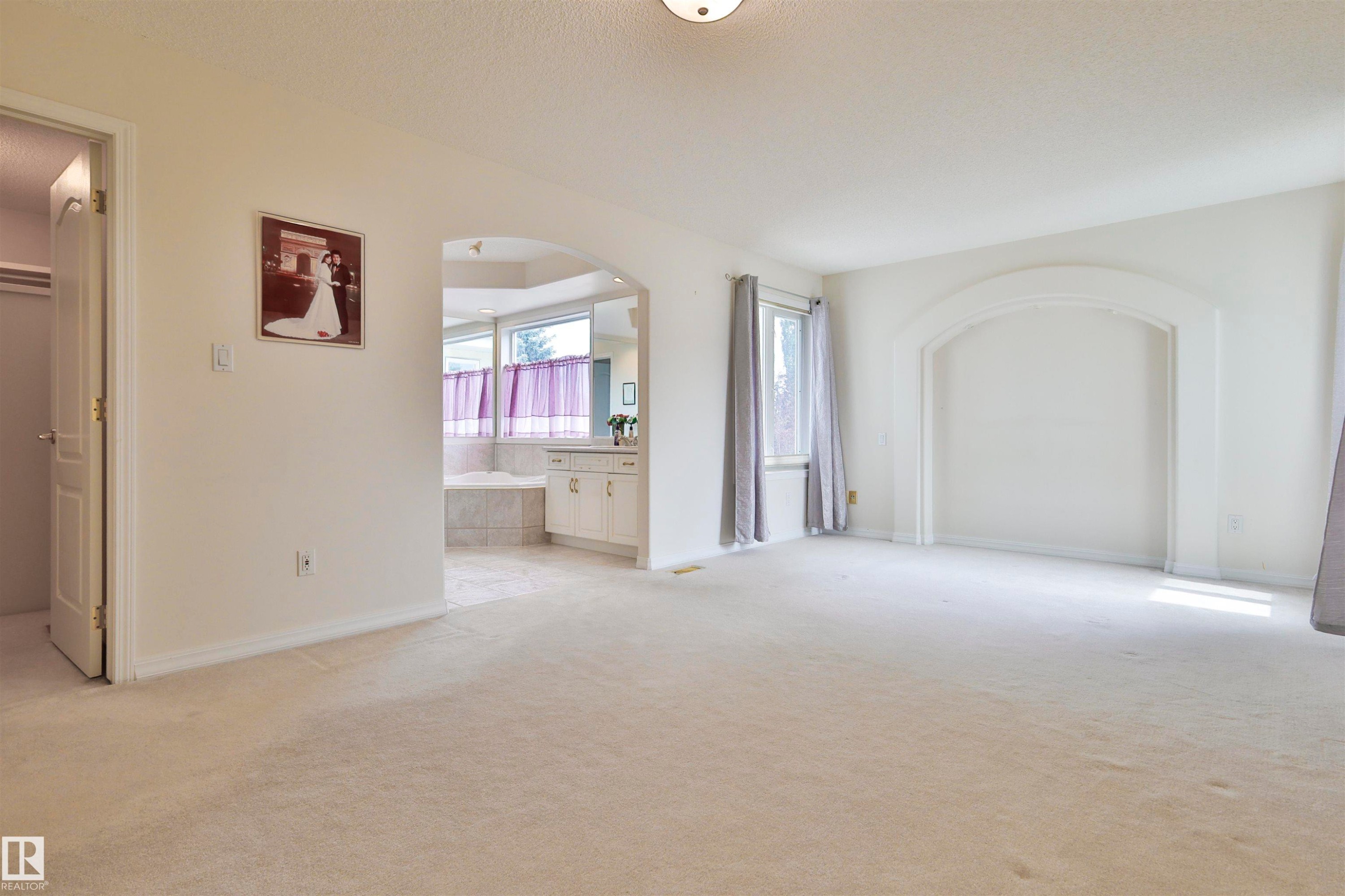 Carpeted flooring, arched architectural detail, recessed alcove, double-pane window, built-in vanity with cabinetry - 237 Darlington Crescent Nw, Edmonton, AB - Indoor Photo Showing Other Room