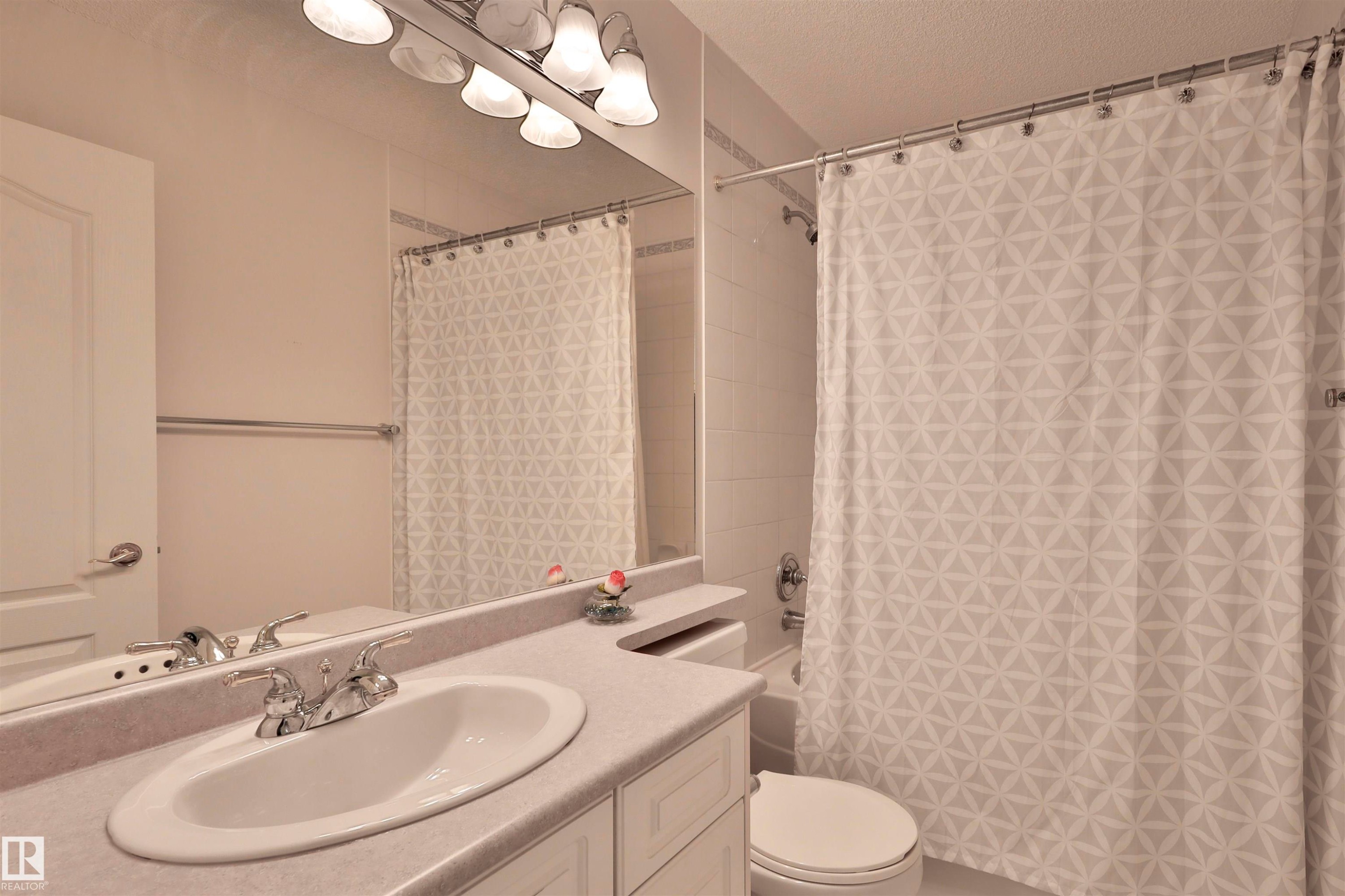 Vanity with an integrated sink, polished chrome faucet, and storage cabinetry - 237 Darlington Crescent Nw, Edmonton, AB - Indoor Photo Showing Bathroom