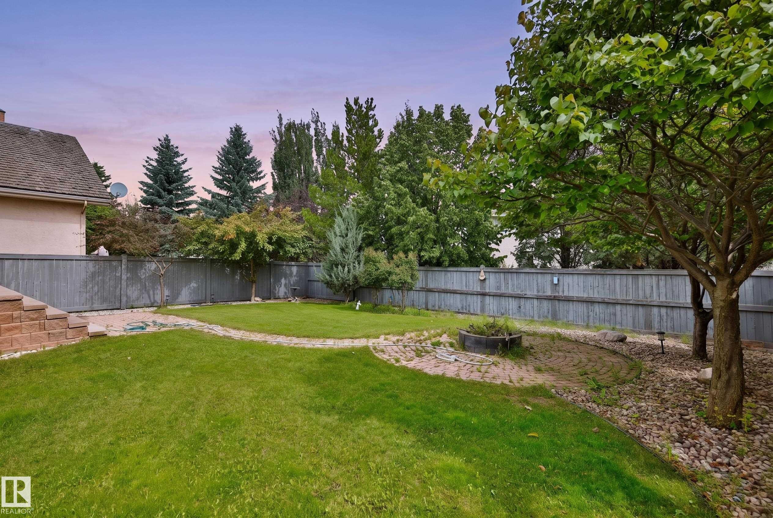 Expansive backyard featuring a manicured lawn, mature trees, and a privacy fence - 237 Darlington Crescent Nw, Edmonton, AB - Outdoor With Backyard