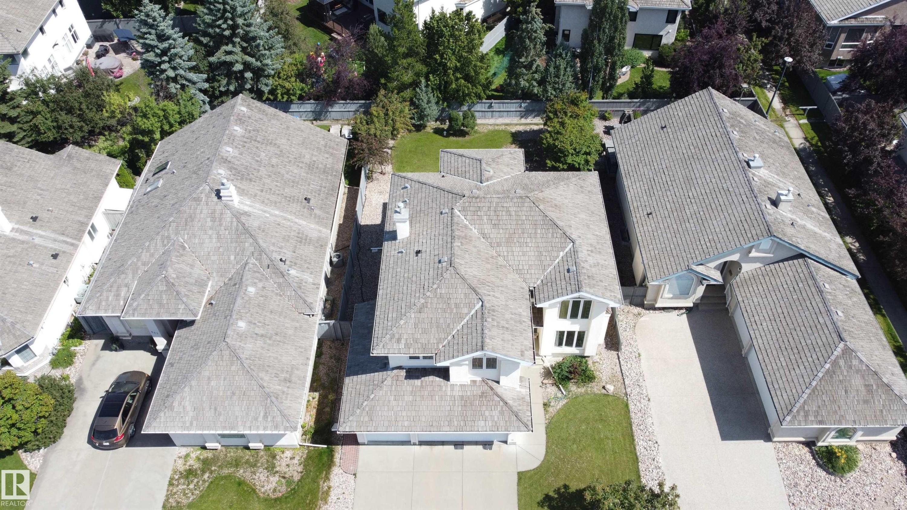 Gabled roofline with light-colored shingles, multiple dormer windows, and a prominent chimney feature - 237 Darlington Crescent Nw, Edmonton, AB - Outdoor