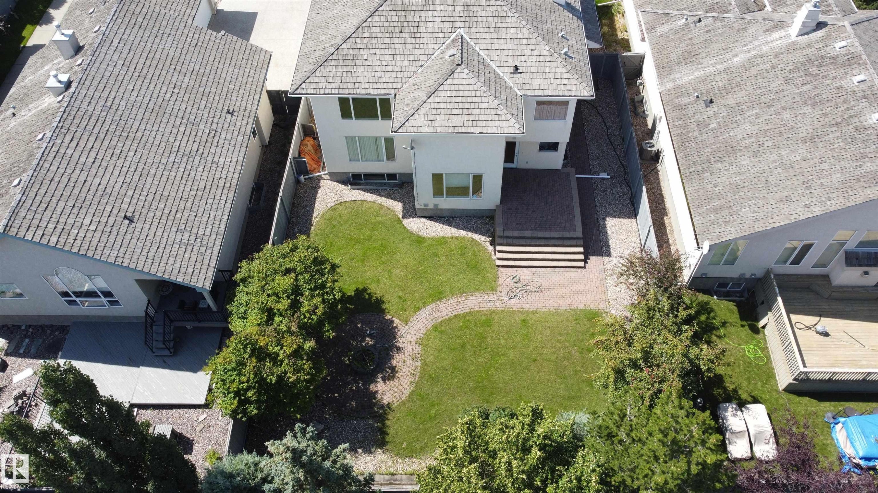 Rear exterior with a multi-level deck, patterned hardscaping, and a landscaped lawn - 237 Darlington Crescent Nw, Edmonton, AB - Outdoor