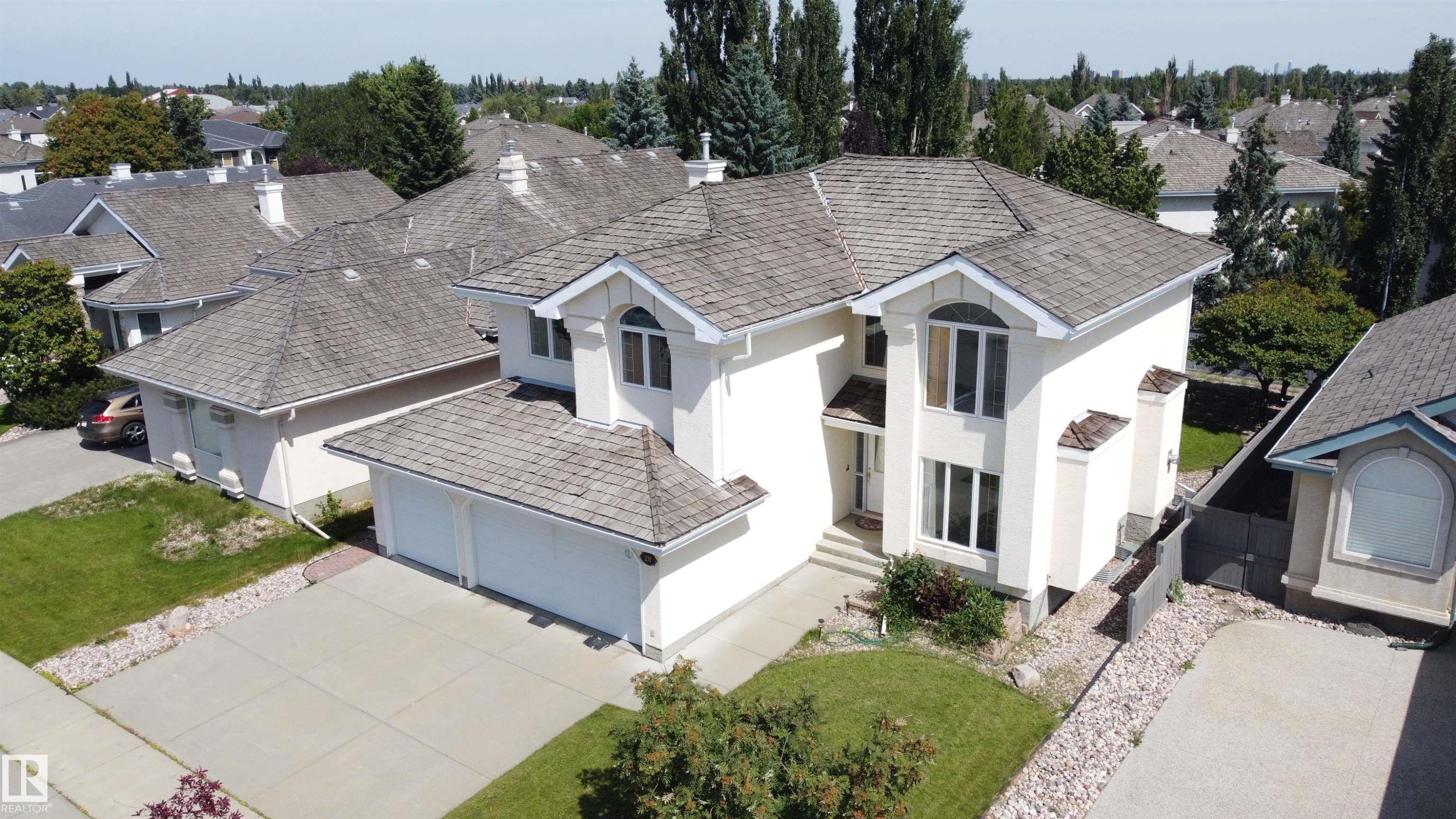 Cream stucco exterior with a multi-gabled shingle roof - 237 Darlington Crescent Nw, Edmonton, AB - Outdoor