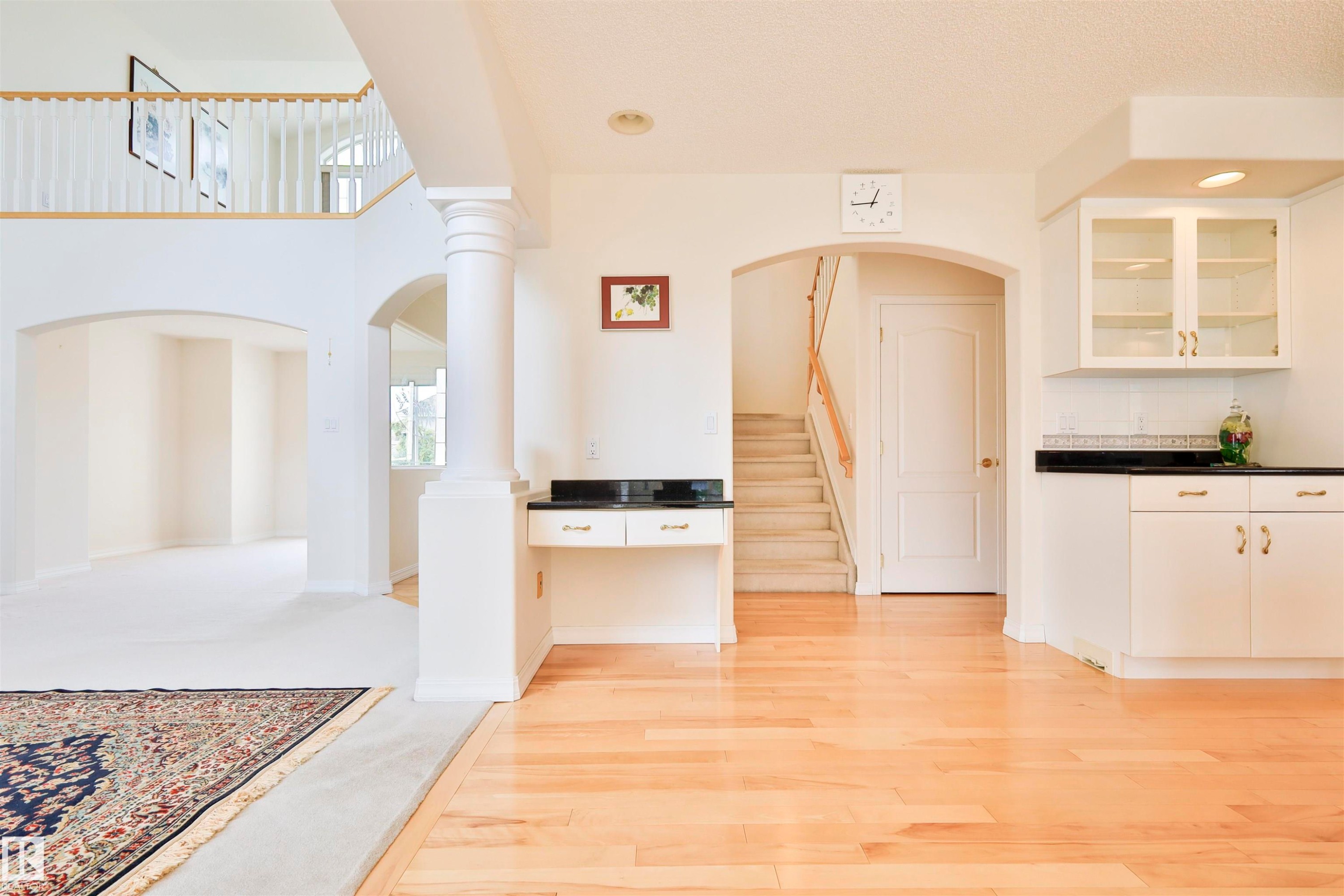Hardwood flooring, arched doorways, white painted cabinetry, built-in desk, and an upper-level balcony - 237 Darlington Crescent Nw, Edmonton, AB - Indoor