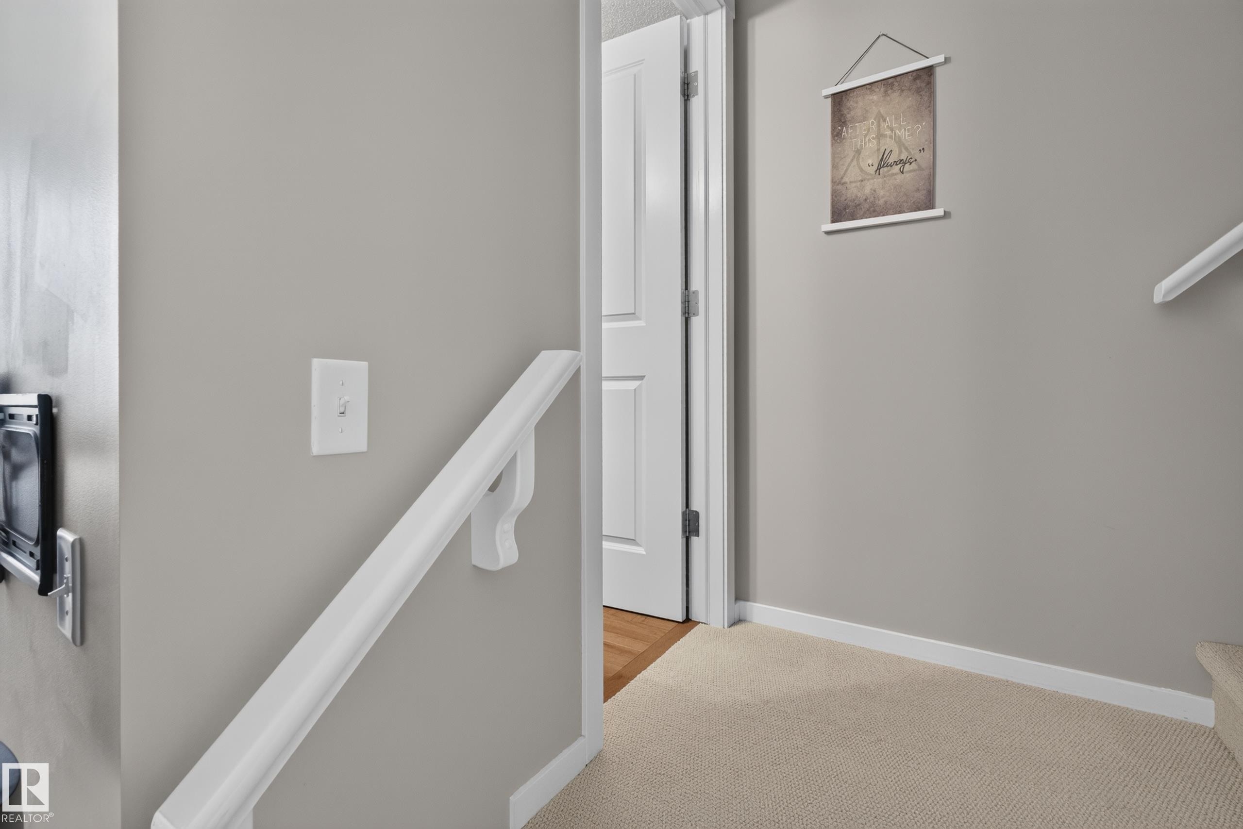 Neutral tone walls complement the white trim and white painted door - #53 603 Watt Bv Sw, Edmonton, AB - Indoor Photo Showing Other Room