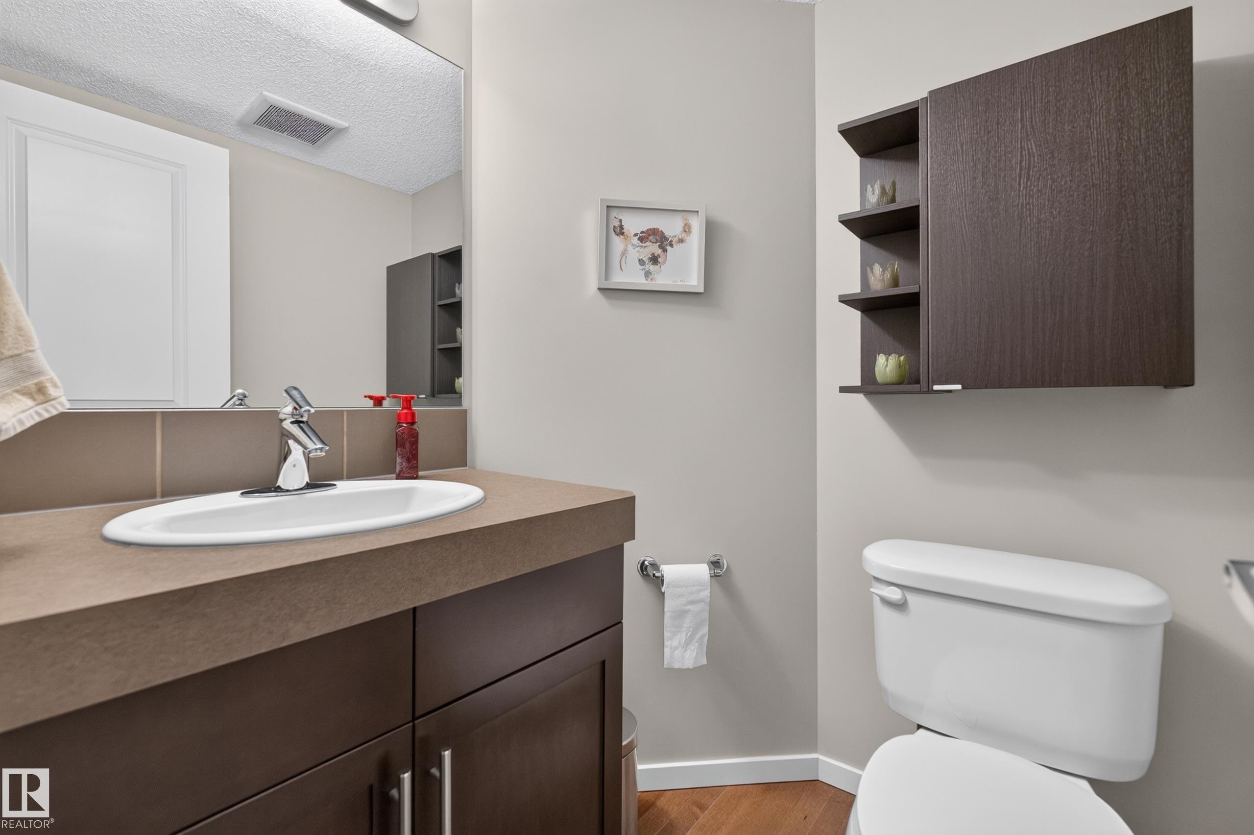 Bathroom vanity with a rectangular undermount sink, chrome faucet, and brown countertop - #53 603 Watt Bv Sw, Edmonton, AB - Indoor Photo Showing Bathroom