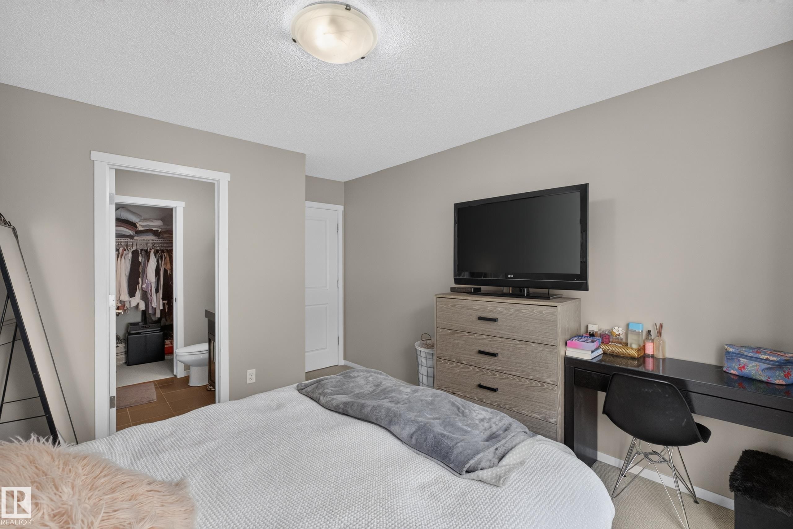 Neutral-toned bedroom featuring a textured ceiling, a flush-mount ceiling light, and light-colored walls - #53 603 Watt Bv Sw, Edmonton, AB - Indoor Photo Showing Bedroom