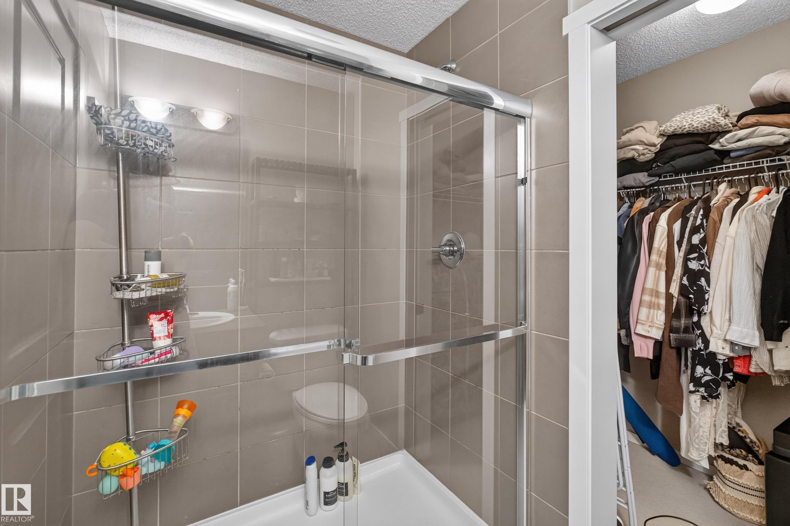Glass-enclosed shower with subway tile surround, white shower pan, and chrome fixtures - #53 603 Watt Bv Sw, Edmonton, AB - Indoor Photo Showing Bathroom
