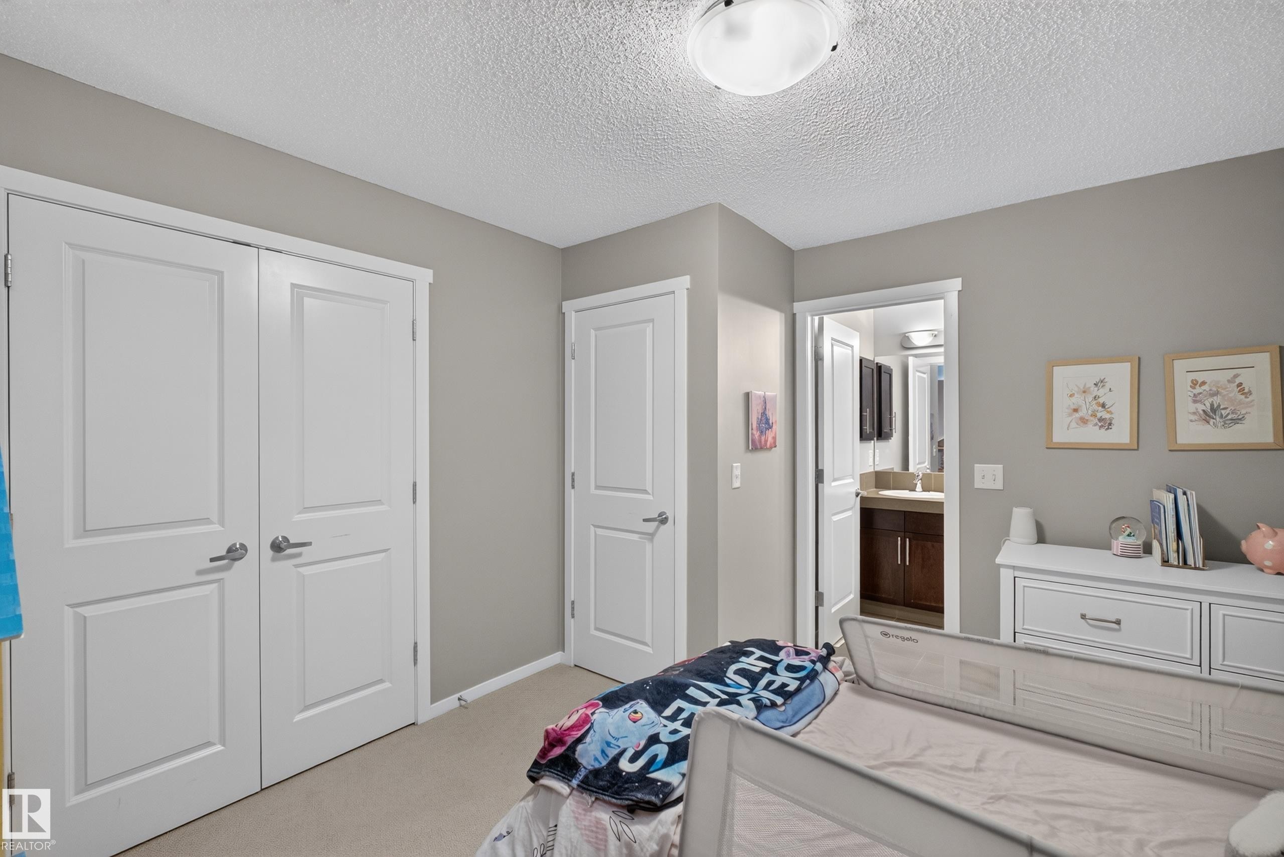 Neutral-toned room featuring a flush-mount ceiling light and two-panel interior doors - #53 603 Watt Bv Sw, Edmonton, AB - Indoor Photo Showing Bedroom
