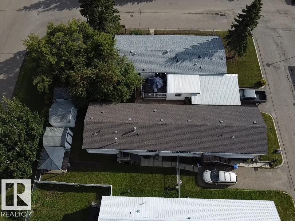Property featuring multiple structures with shingled roofs and a paved driveway - #56 4202 45 St, Wetaskiwin, AB - Outdoor