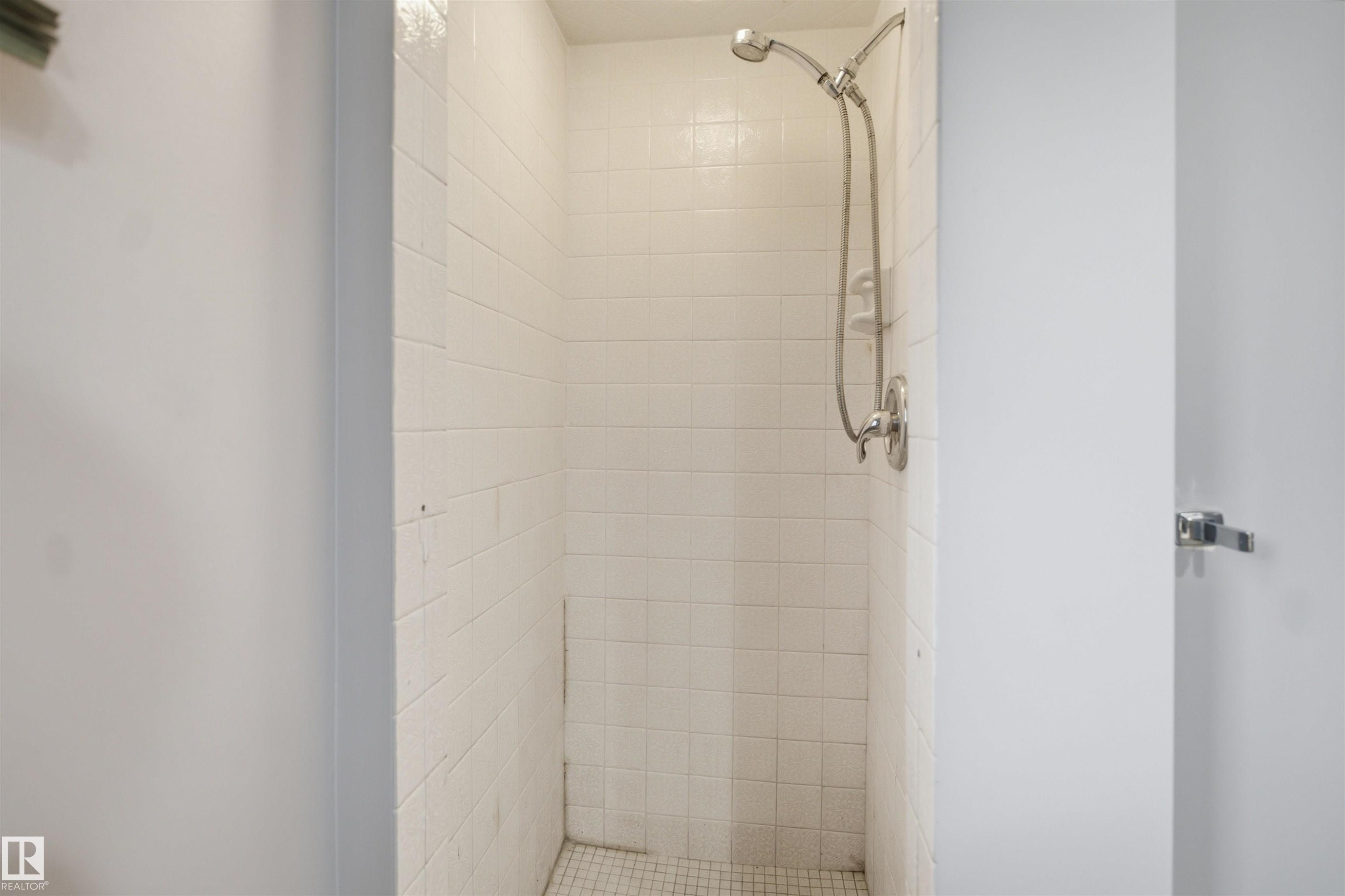 White tiled shower enclosure with a chrome shower head and fixture - 3432 Hill View Crescent Nw, Edmonton, AB - Indoor Photo Showing Bathroom