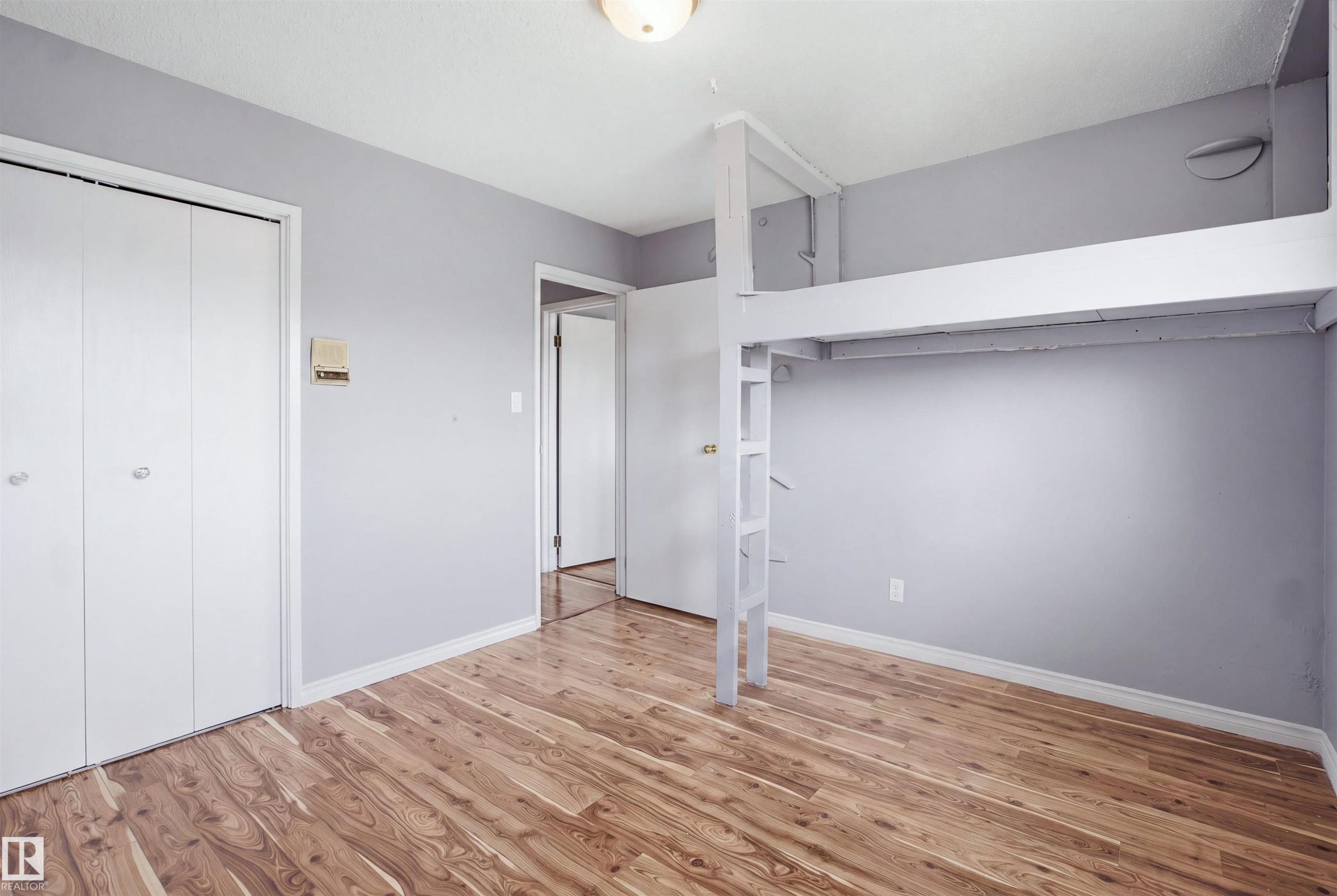 Wood-finish flooring, built-in loft structure, and bi-fold closet doors - 3432 Hill View Crescent Nw, Edmonton, AB - Indoor Photo Showing Other Room