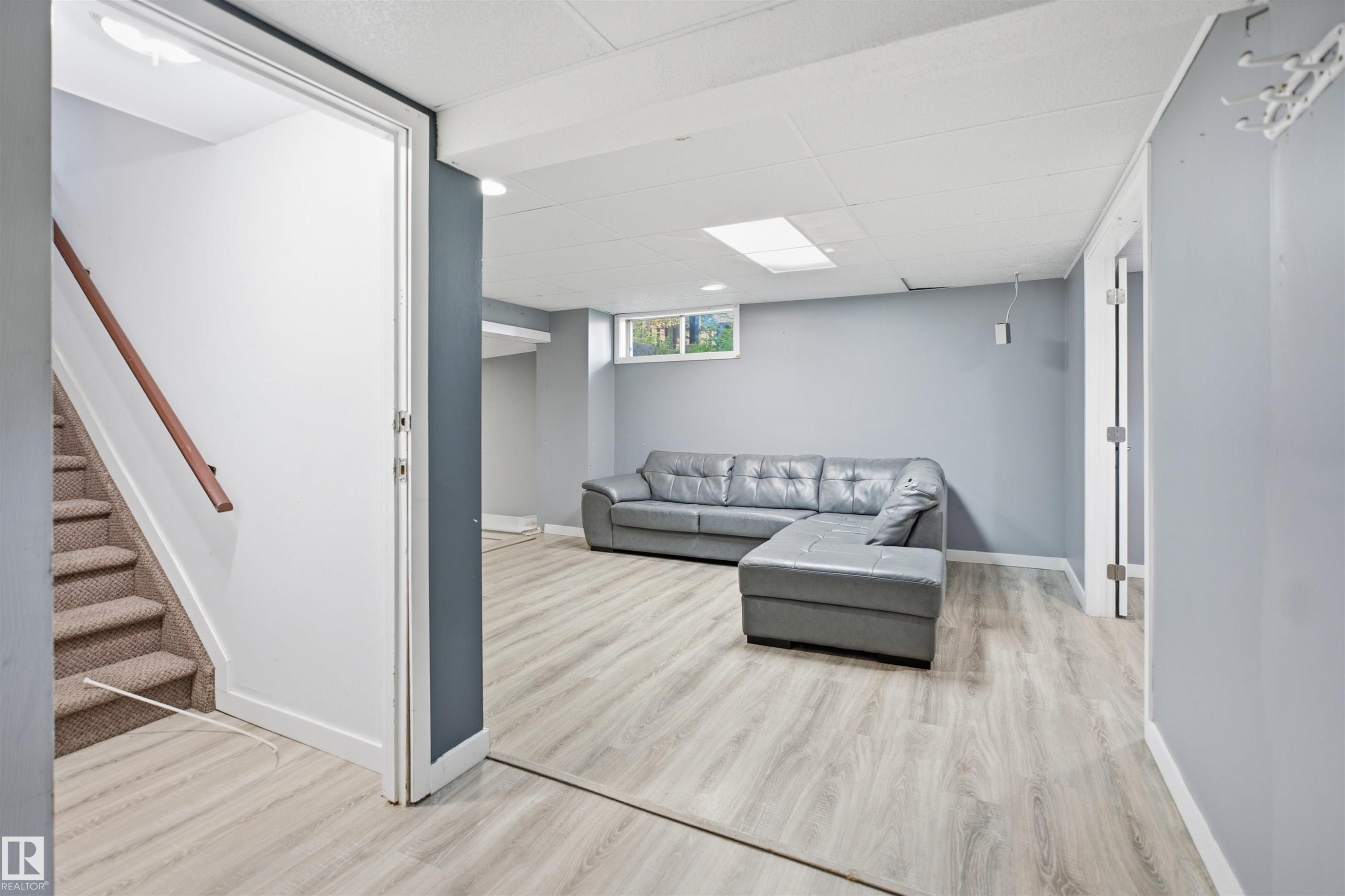 Finished lower level with light wood-finish flooring, recessed lighting, drop ceiling, and a single window - 3432 Hill View Crescent Nw, Edmonton, AB - Indoor Photo Showing Other Room