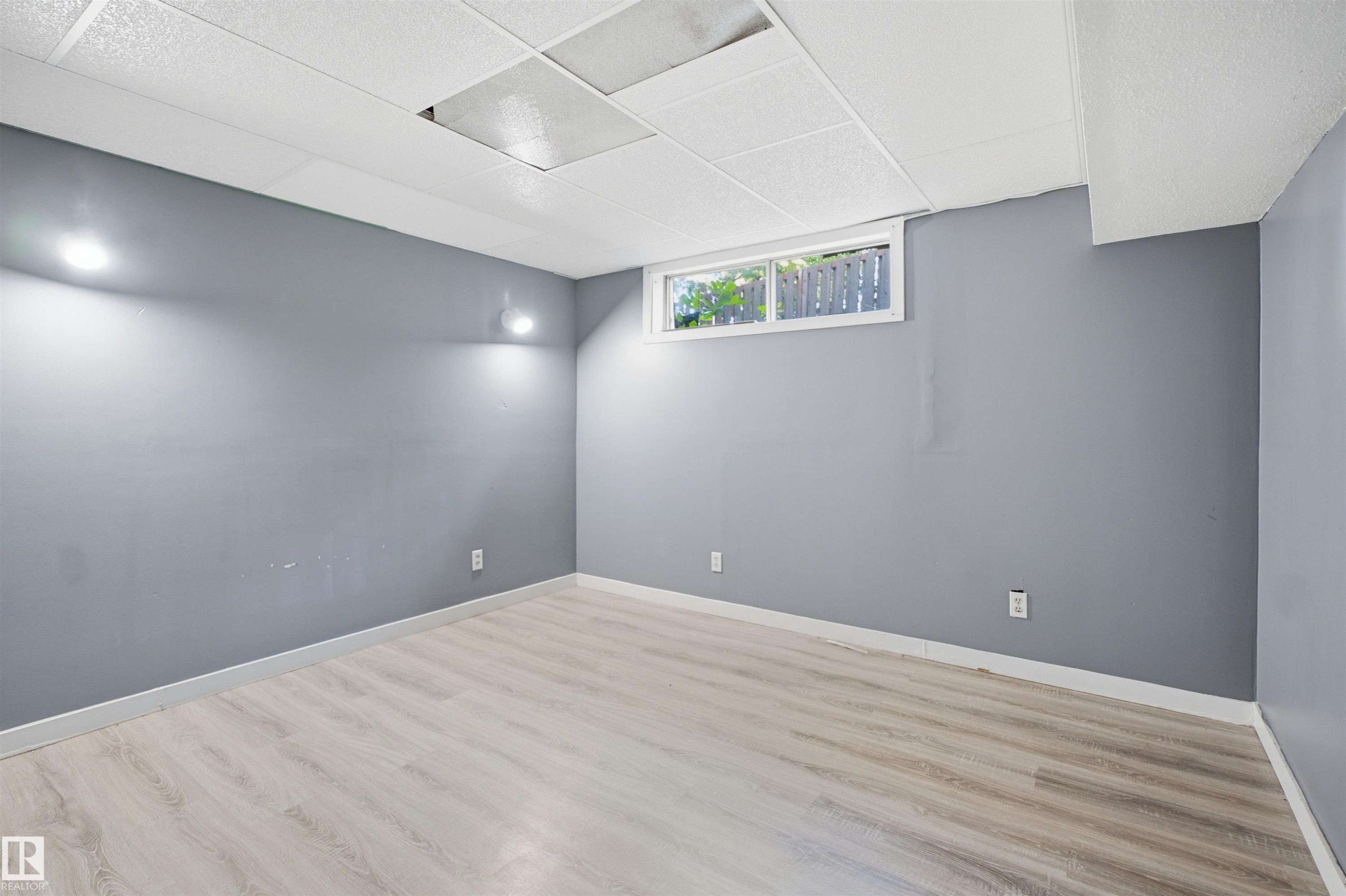 Recessed lighting, drop ceiling, wood-finish flooring, white trim, and a horizontal window - 3432 Hill View Crescent Nw, Edmonton, AB - Indoor Photo Showing Other Room