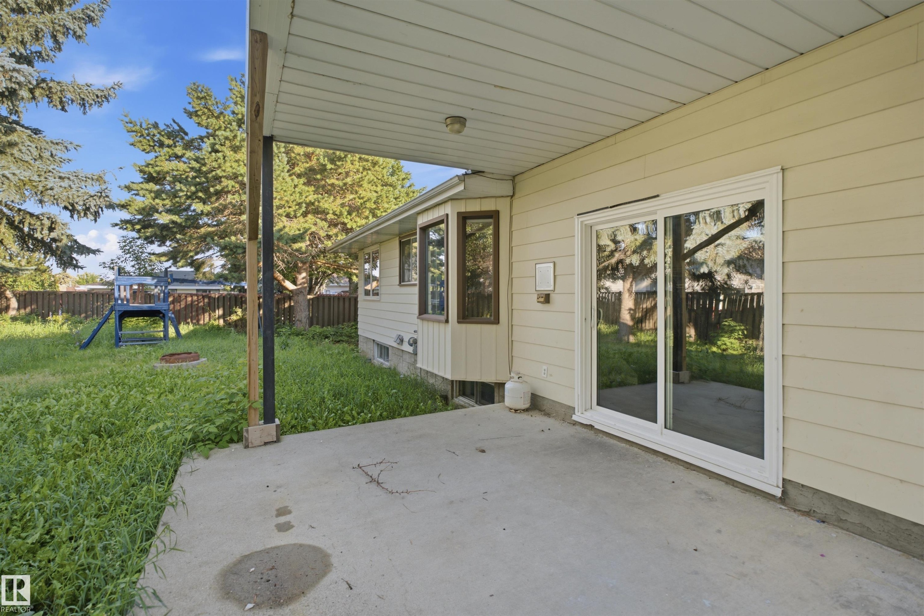 Concrete patio with a covered section, siding exterior, and sliding glass door - 3432 Hill View Crescent Nw, Edmonton, AB - Outdoor With Exterior