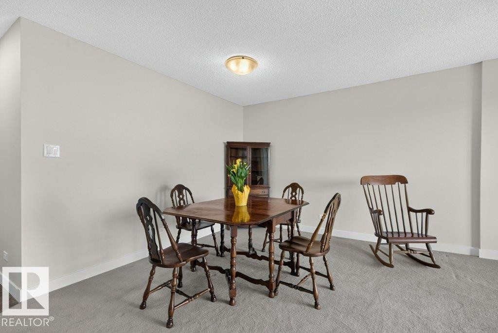 Neutral-toned room featuring a light-colored wall finish, white baseboards, and textured ceiling - #804 11027 87 Av Nw, Edmonton, AB - Indoor Photo Showing Dining Room