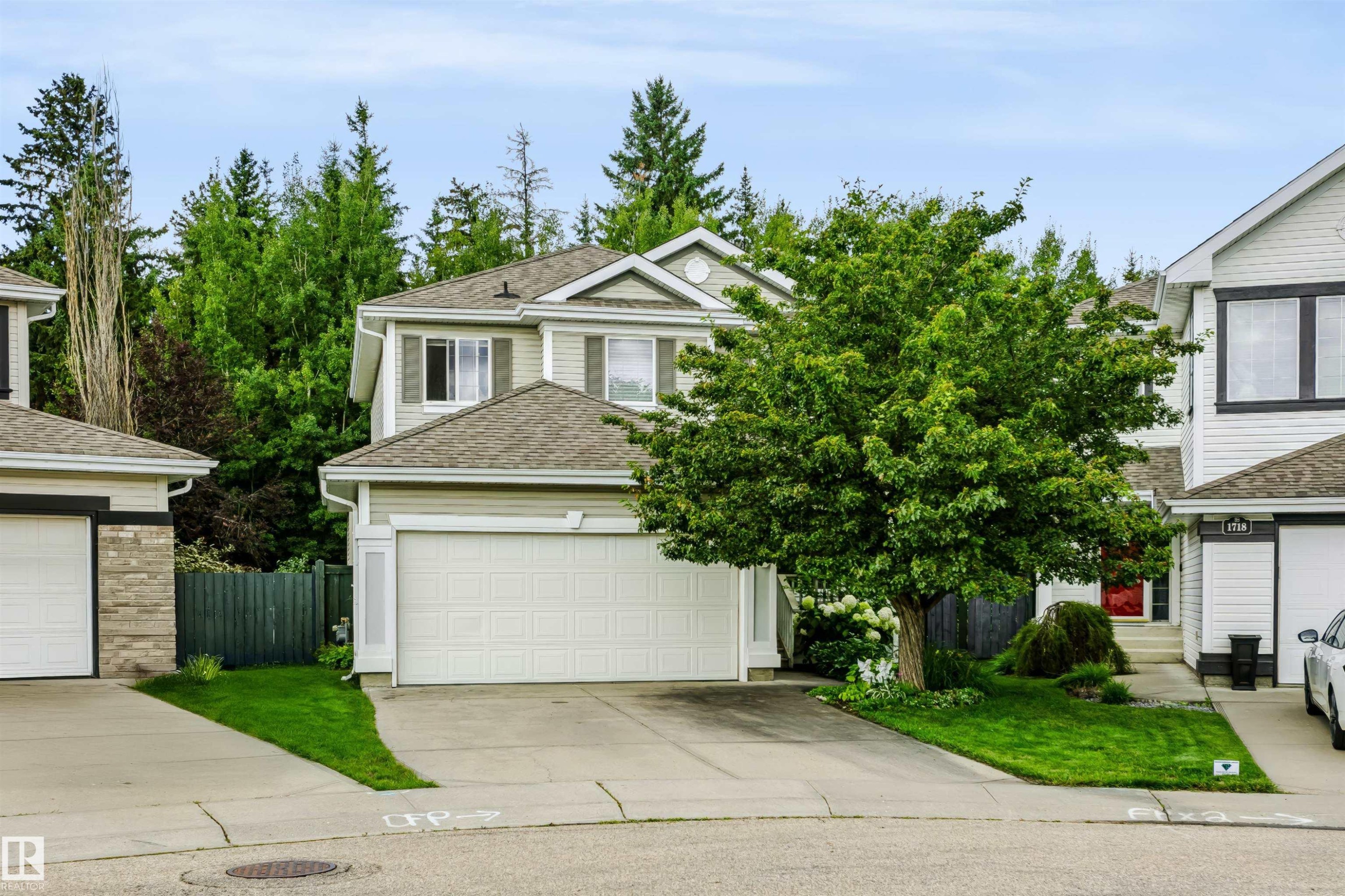 Two-story residence with light-toned siding, attached garage, and a gabled roofline - 1720 Robertson Place Sw, Edmonton, AB - Outdoor