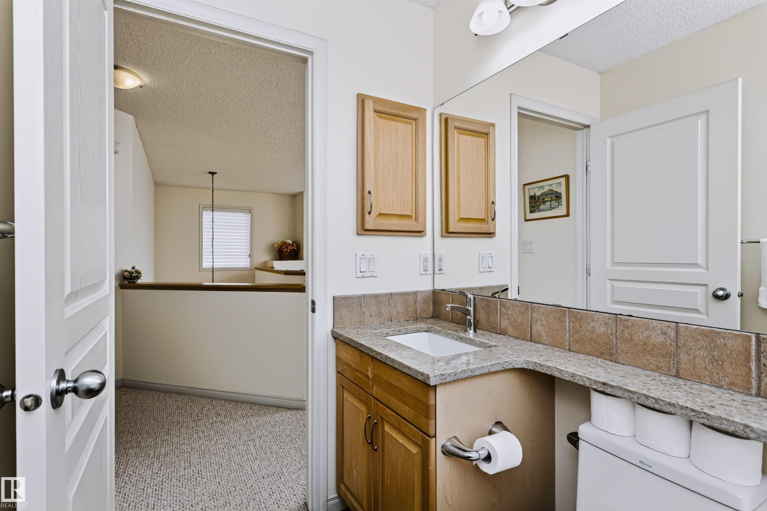 Vanity with a granite countertop, undermount sink, and wood-finish cabinetry - 1720 Robertson Place Sw, Edmonton, AB - Indoor Photo Showing Bathroom