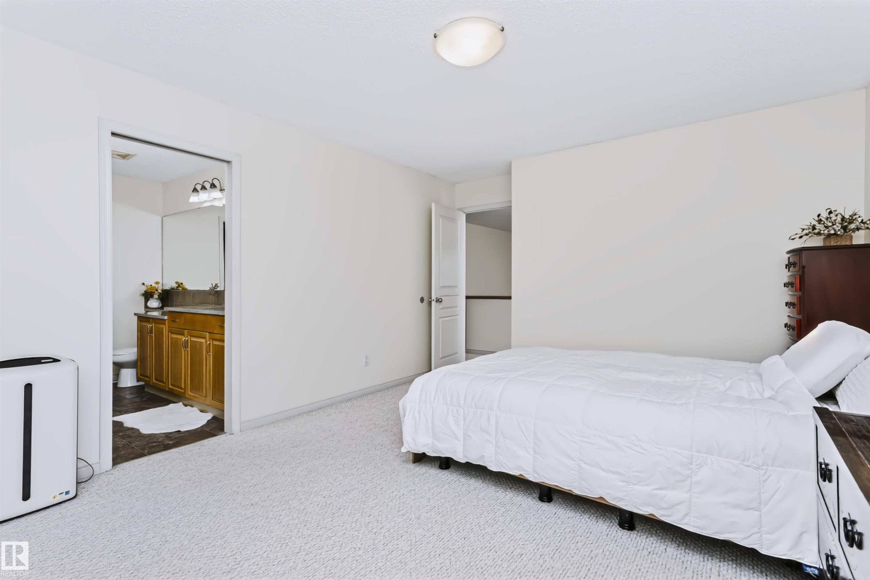White wall paint, light-toned carpeting, and a flush mount ceiling light fixture - 1720 Robertson Place Sw, Edmonton, AB - Indoor Photo Showing Bedroom