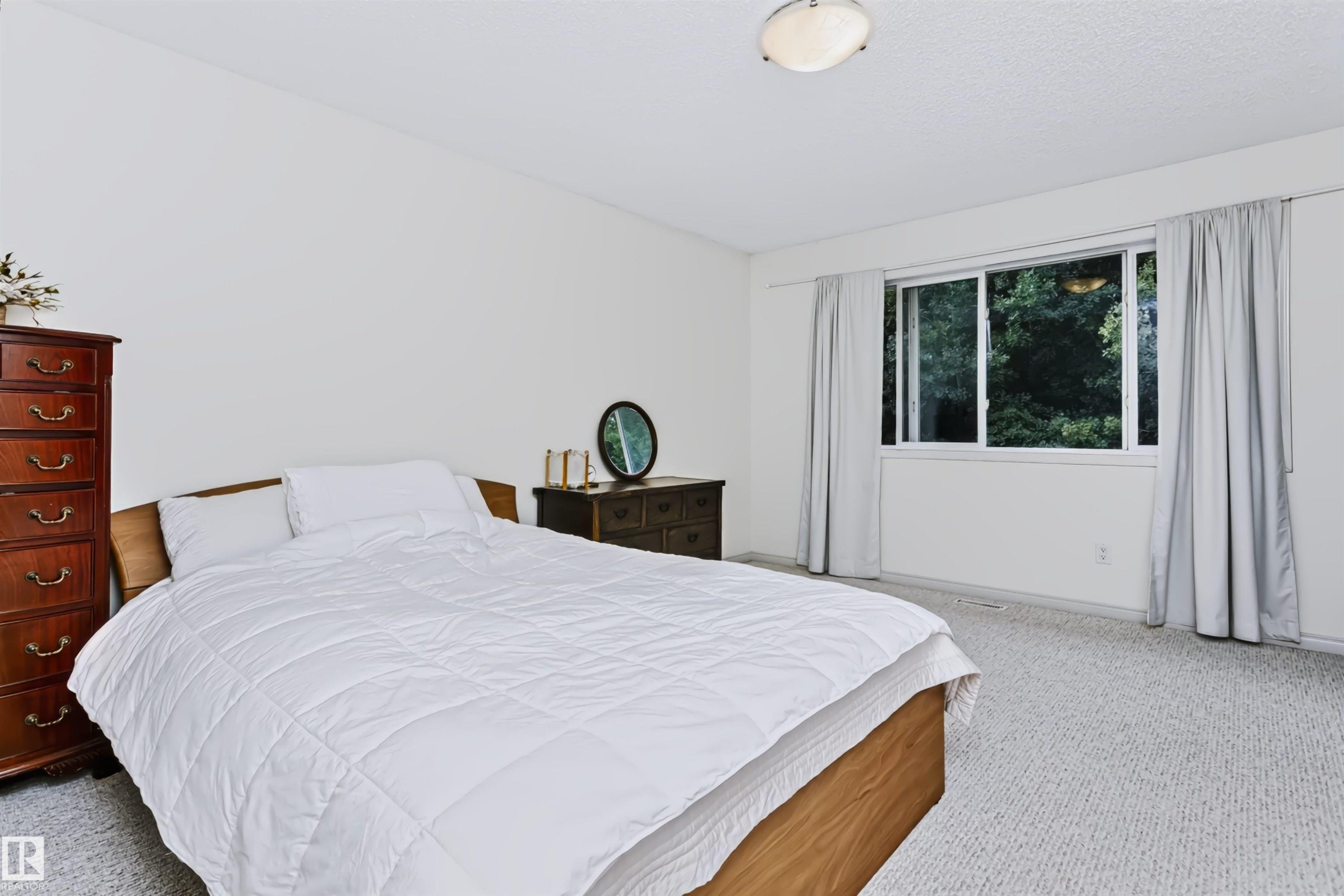 Wall-to-wall carpeting, white walls, and a window with opaque curtains - 1720 Robertson Place Sw, Edmonton, AB - Indoor Photo Showing Bedroom