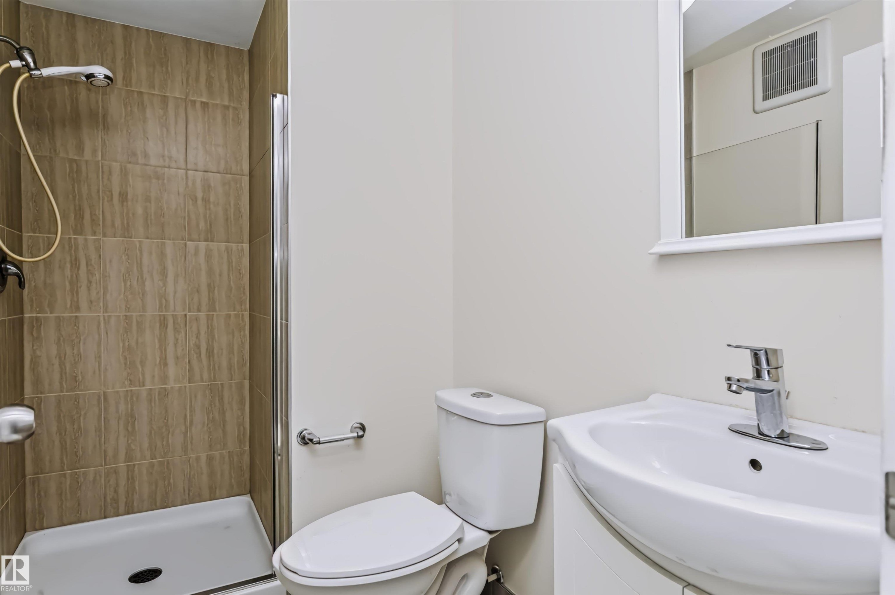 Walk-in shower with tiled surround and glass enclosure - 1720 Robertson Place Sw, Edmonton, AB - Indoor Photo Showing Bathroom