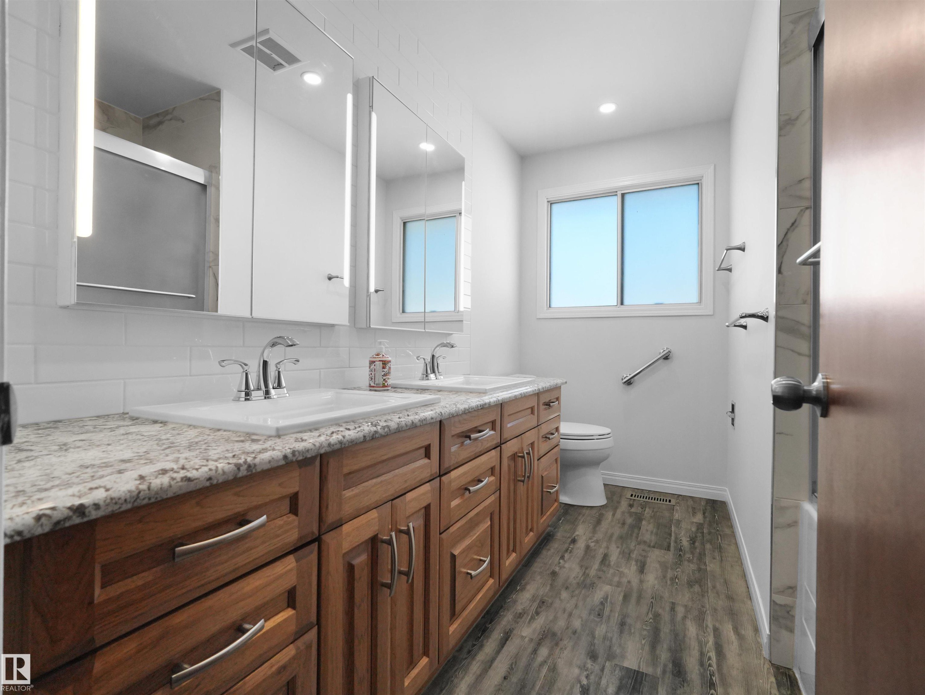 Dual vanity with granite-style countertops and undermount sinks - 7357 18 Avenue Nw, Edmonton, AB - Indoor Photo Showing Bathroom