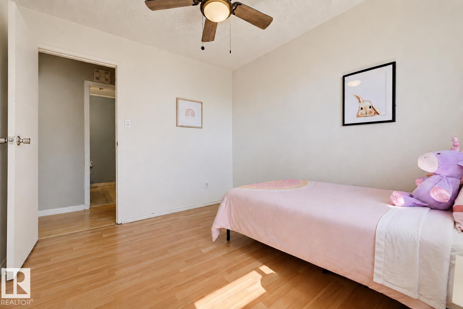 Light wood-finish flooring, white walls, and a ceiling fan with integrated lighting - 6768 39 Avenue Nw, Edmonton, AB - Indoor Photo Showing Bedroom